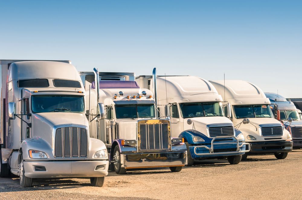 A Row Of Semi Trucks Are Parked In A Parking Lot — R2B Heavy Vehicle Driving School In Marian, QLD