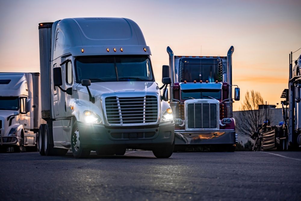 A Row of Semi Trucks Are Parked on the Side of the Road — R2B Heavy Vehicle Driving School In Marian, QLD