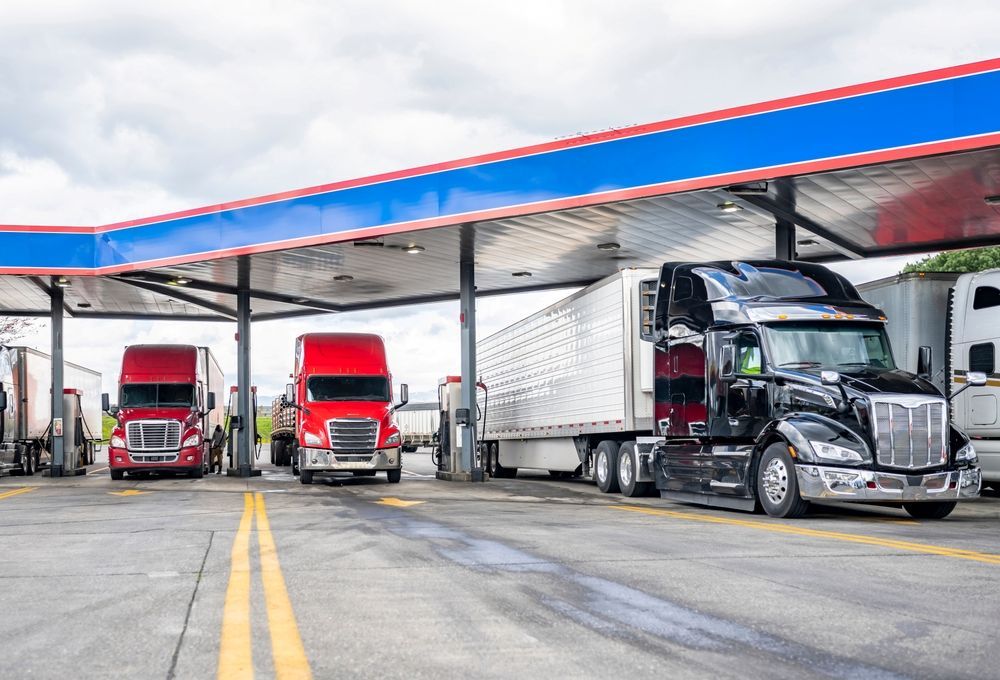 Three Semi Trucks Are Parked at a Gas Station — R2B Heavy Vehicle Driving School In Rural View, QLD