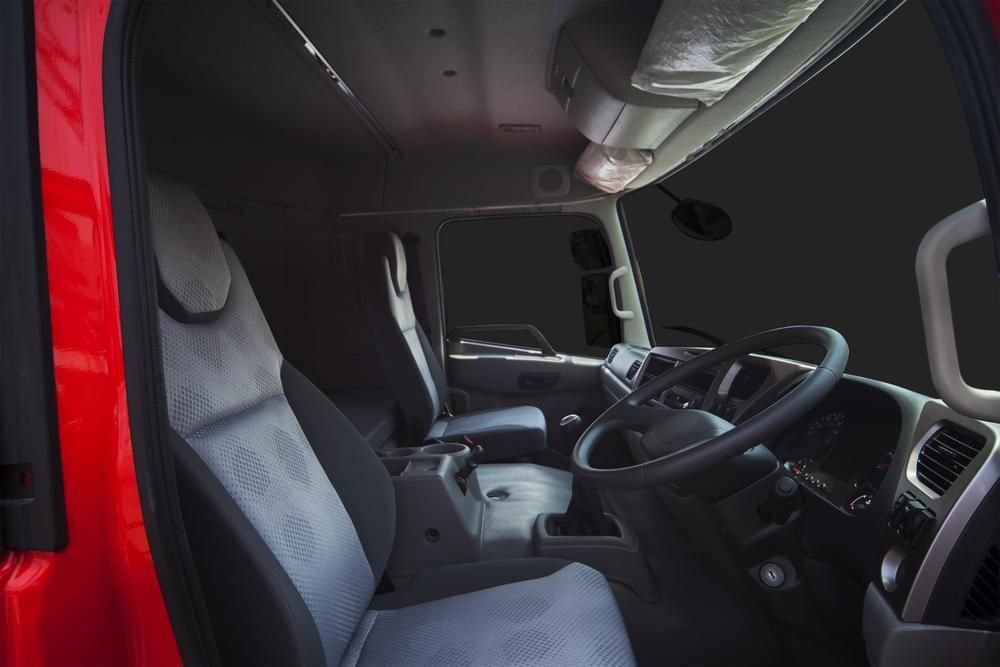 The Interior Of A Red Truck With A Steering Wheel And Seats — R2B Heavy Vehicle Driving School In Mackay, QLD