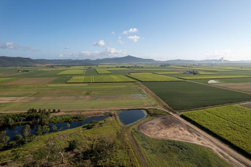 An Aerial View of a Lush Green Field With Mountains in the Background — R2B Heavy Vehicle Driving School in Marian, QLD