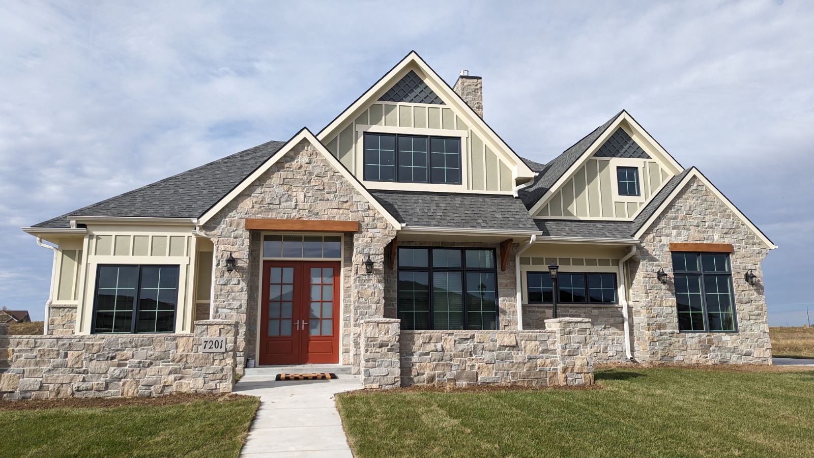 A large house with a lot of windows and a red door