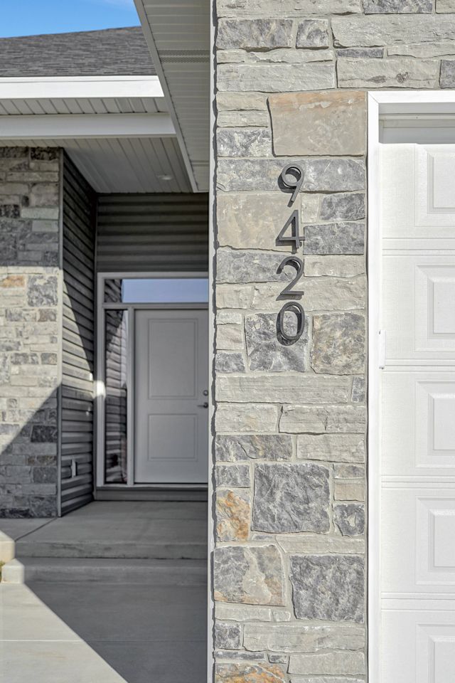 A house with a stone wall and a white garage door.