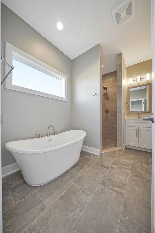 A bathroom with a bathtub and a walk in shower.