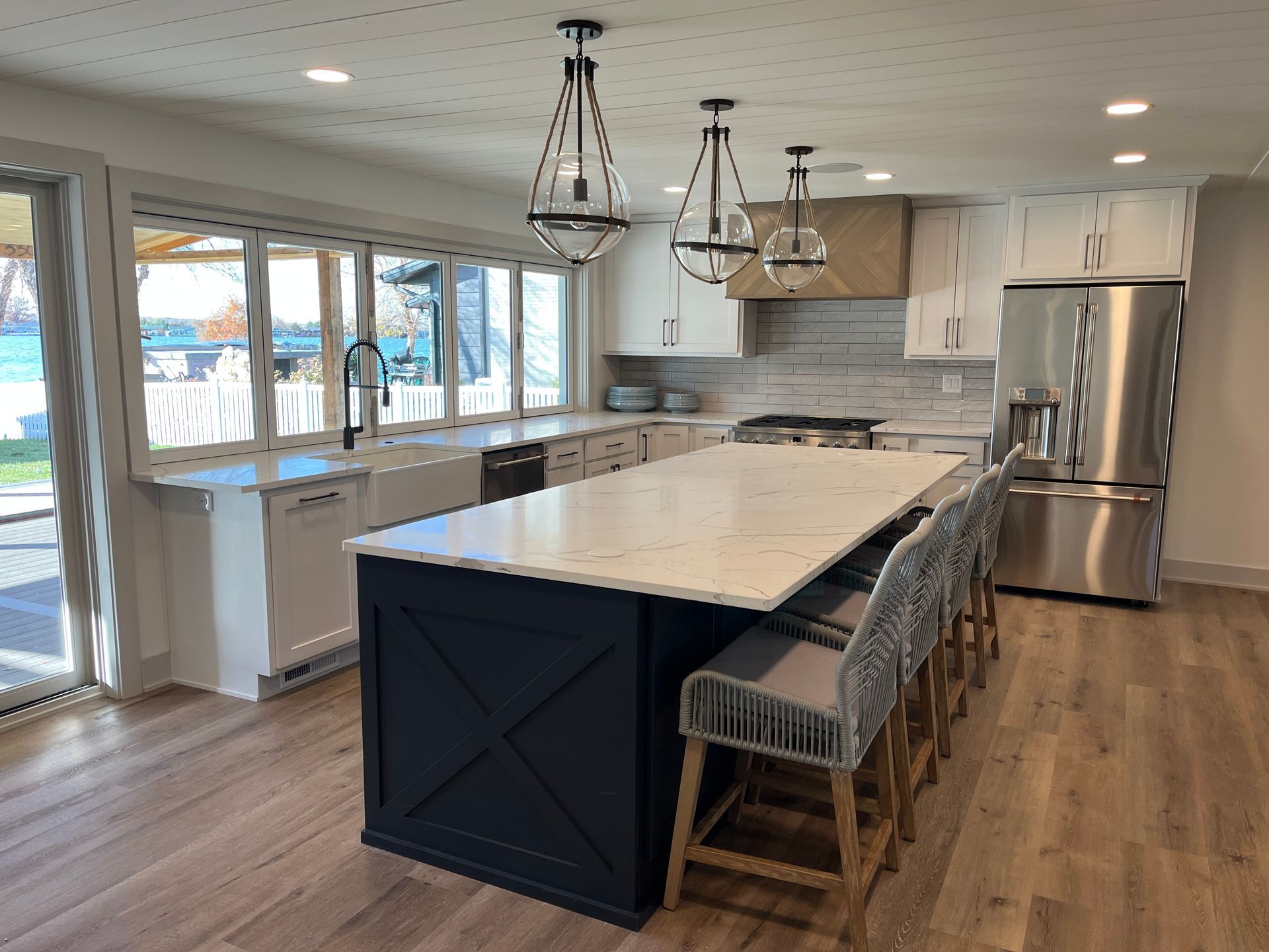 A kitchen with a large island in the middle and stainless steel appliances.