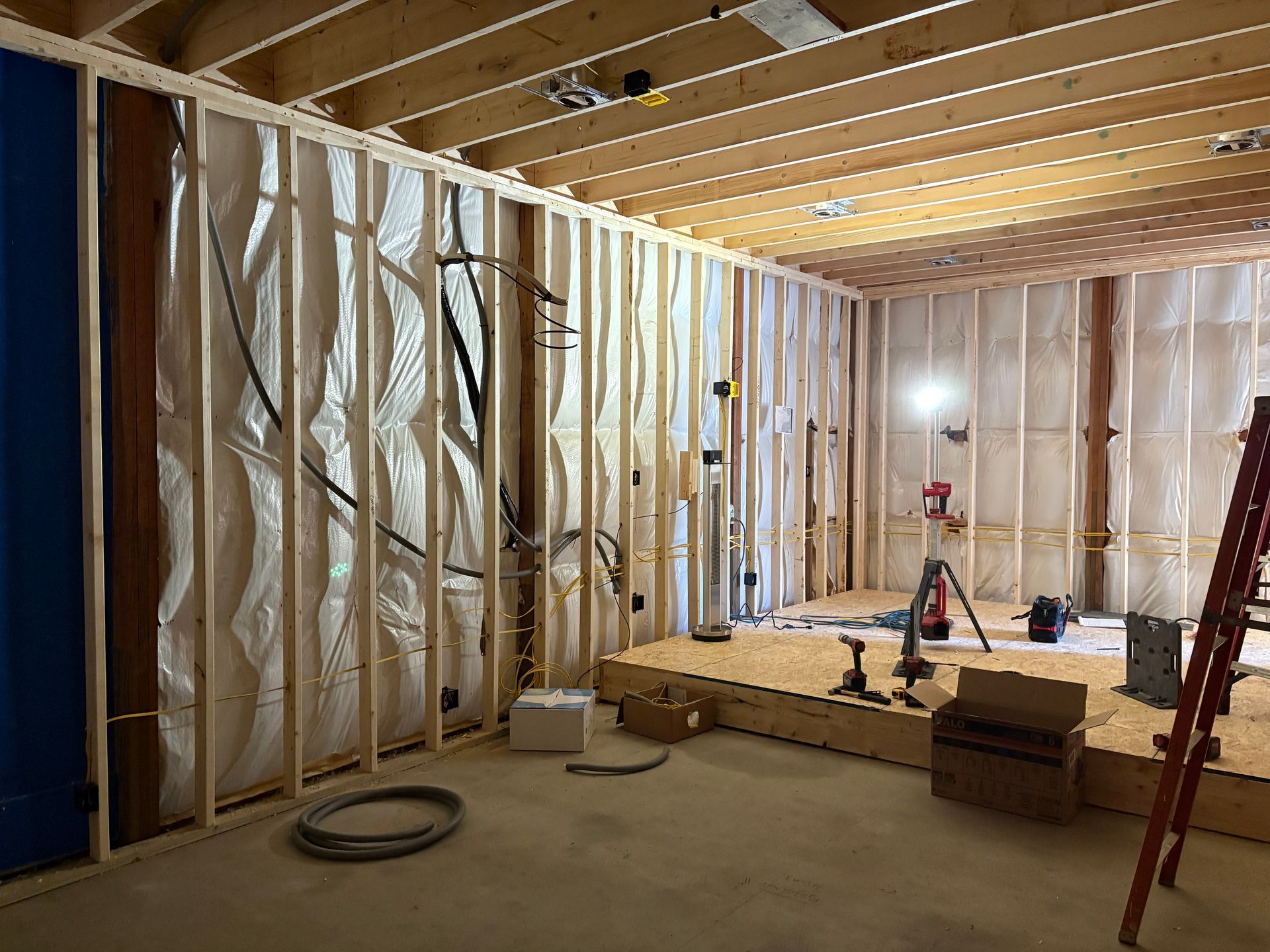 A room in a house under construction with a ladder.