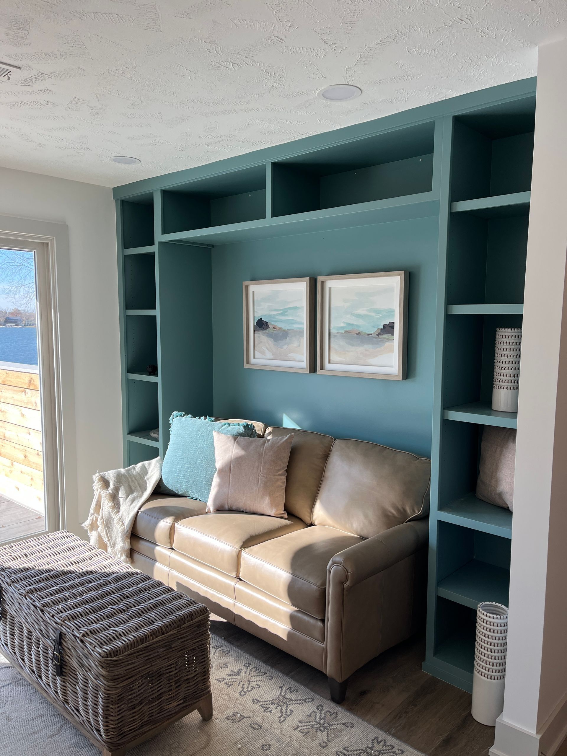 A living room with a couch and wicker ottoman