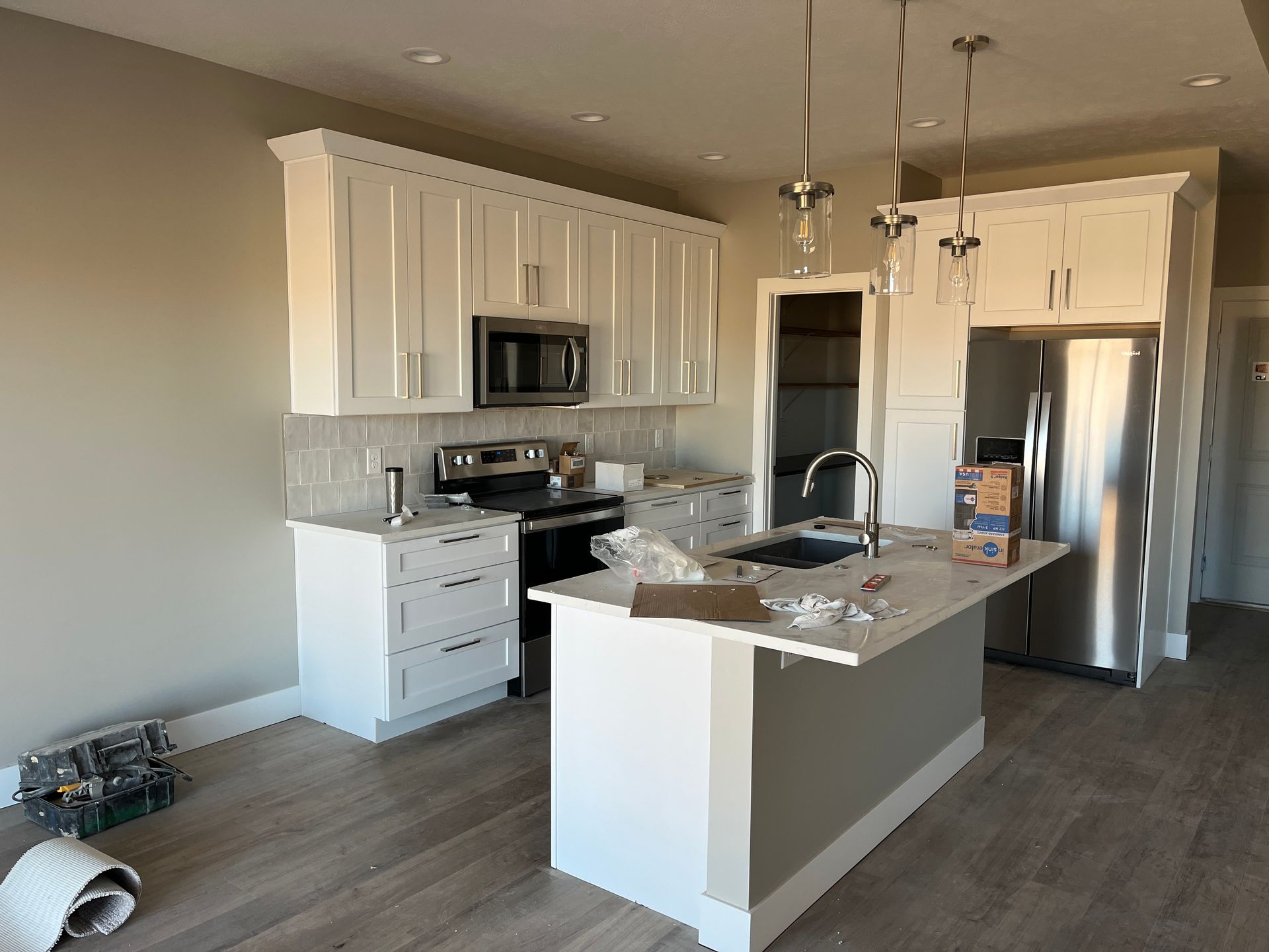 A kitchen with white cabinets and stainless steel appliances