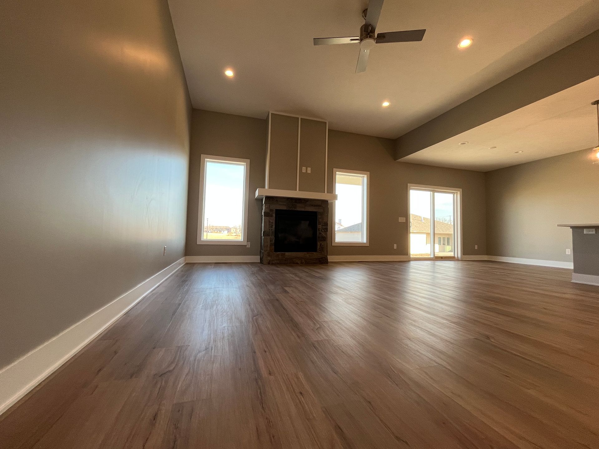An empty living room with hardwood floors and a fireplace.