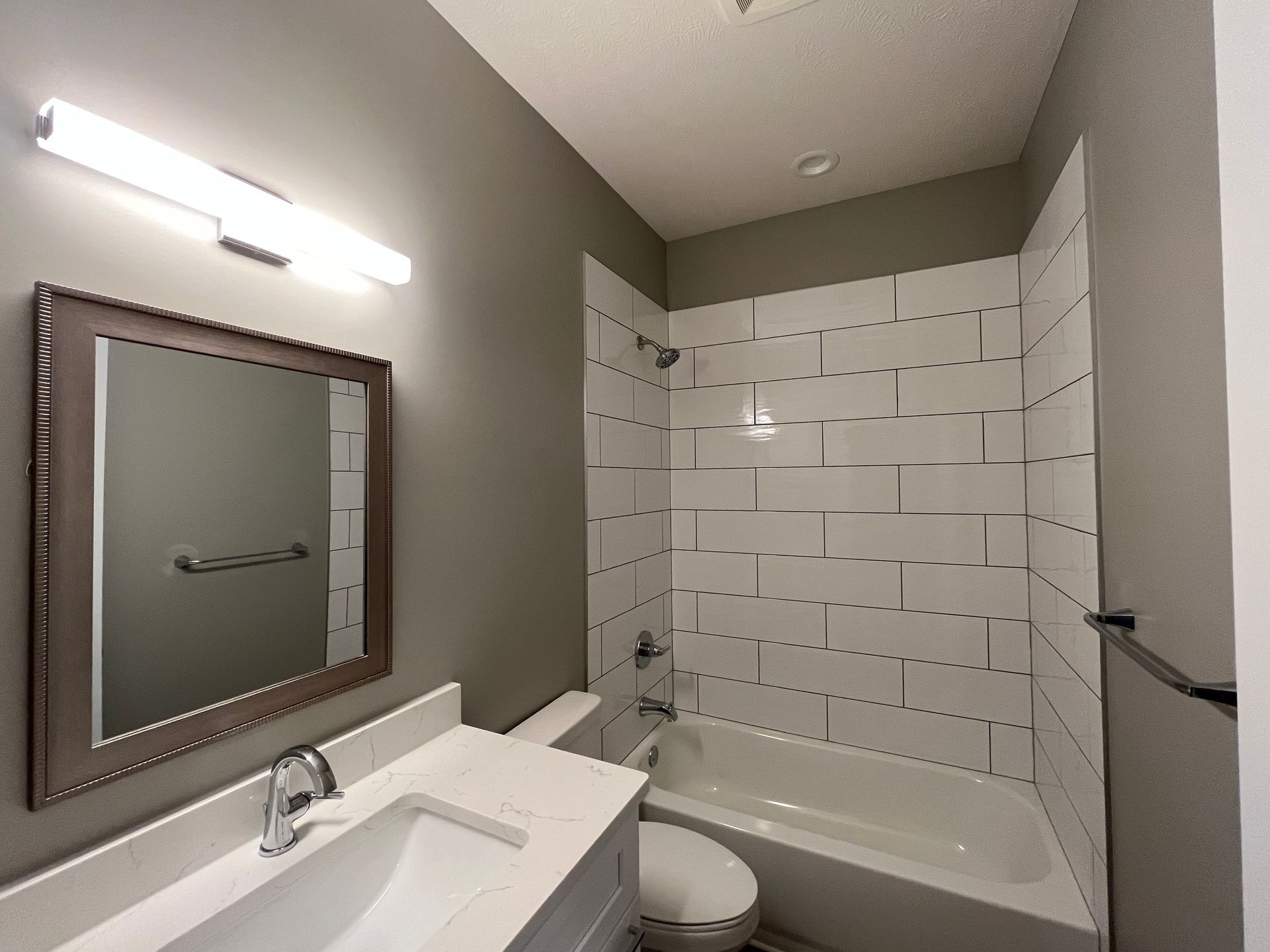 A bathroom with a sink , toilet , bathtub and mirror.