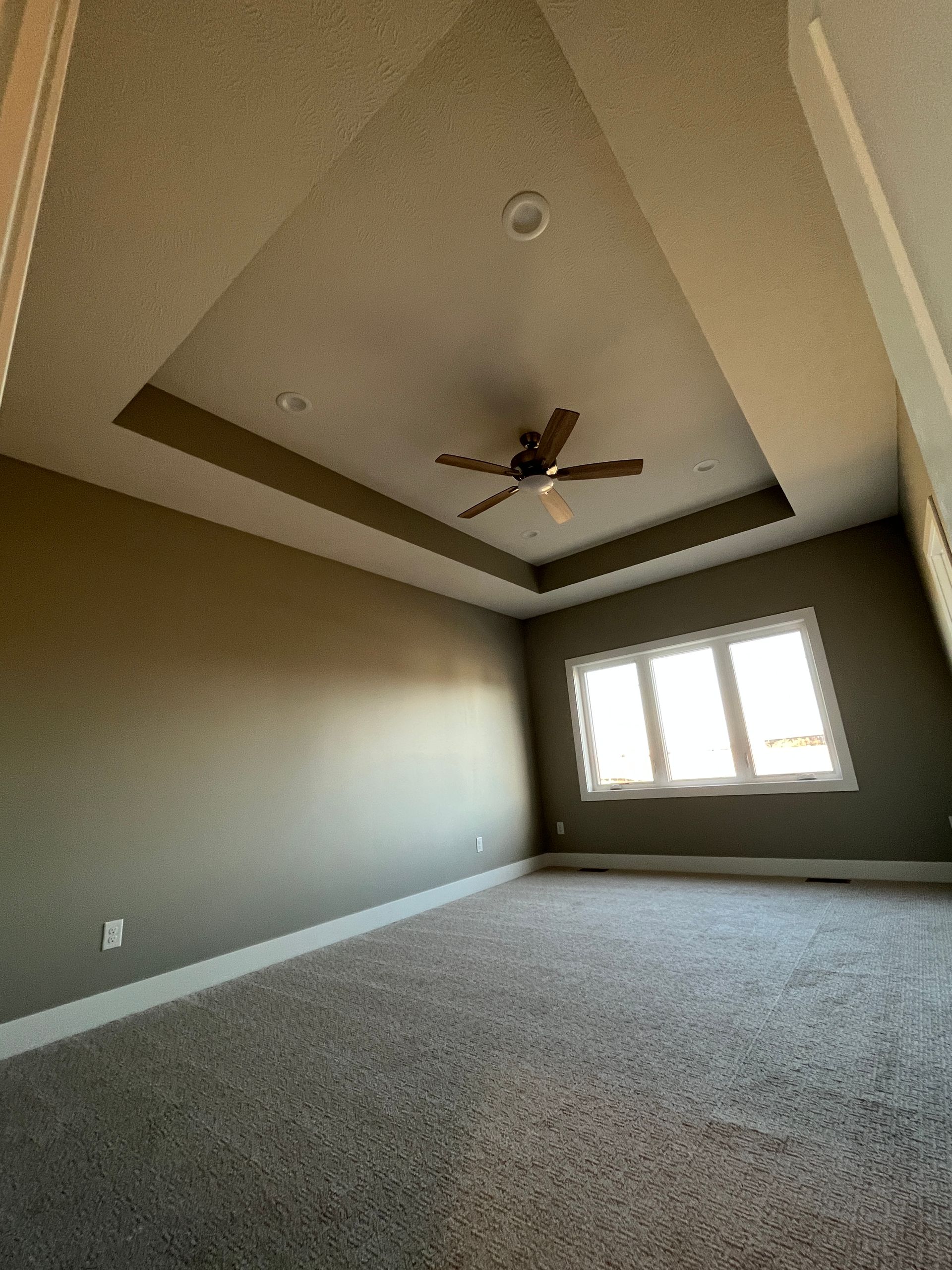 There is a ceiling fan in the corner of the room.