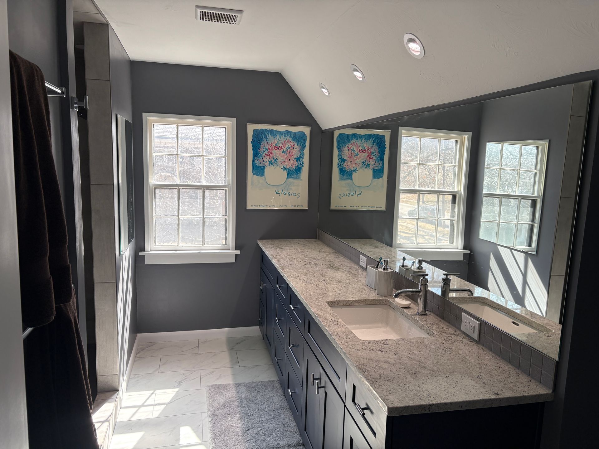 A bathroom with two sinks and a large mirror.