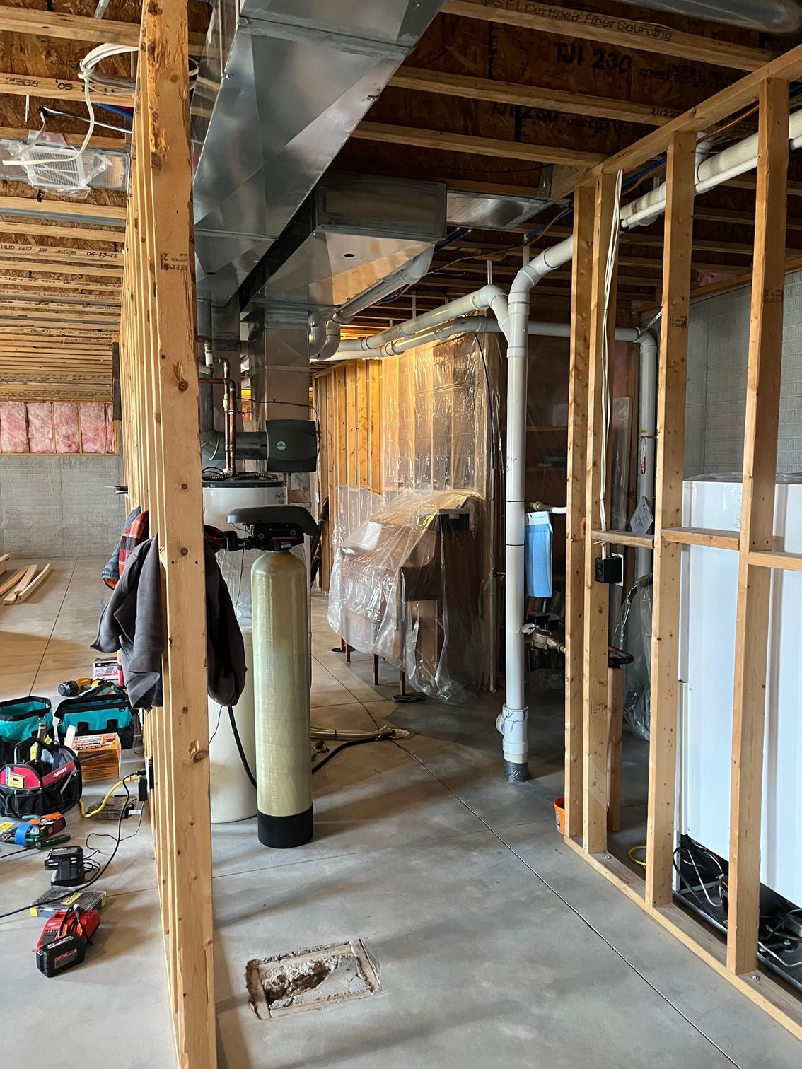 A basement under construction with a water filter and a heater.