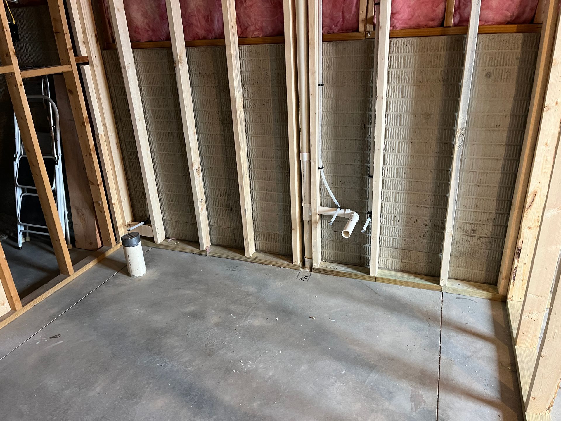 A room in a house under construction with a ladder in the background.