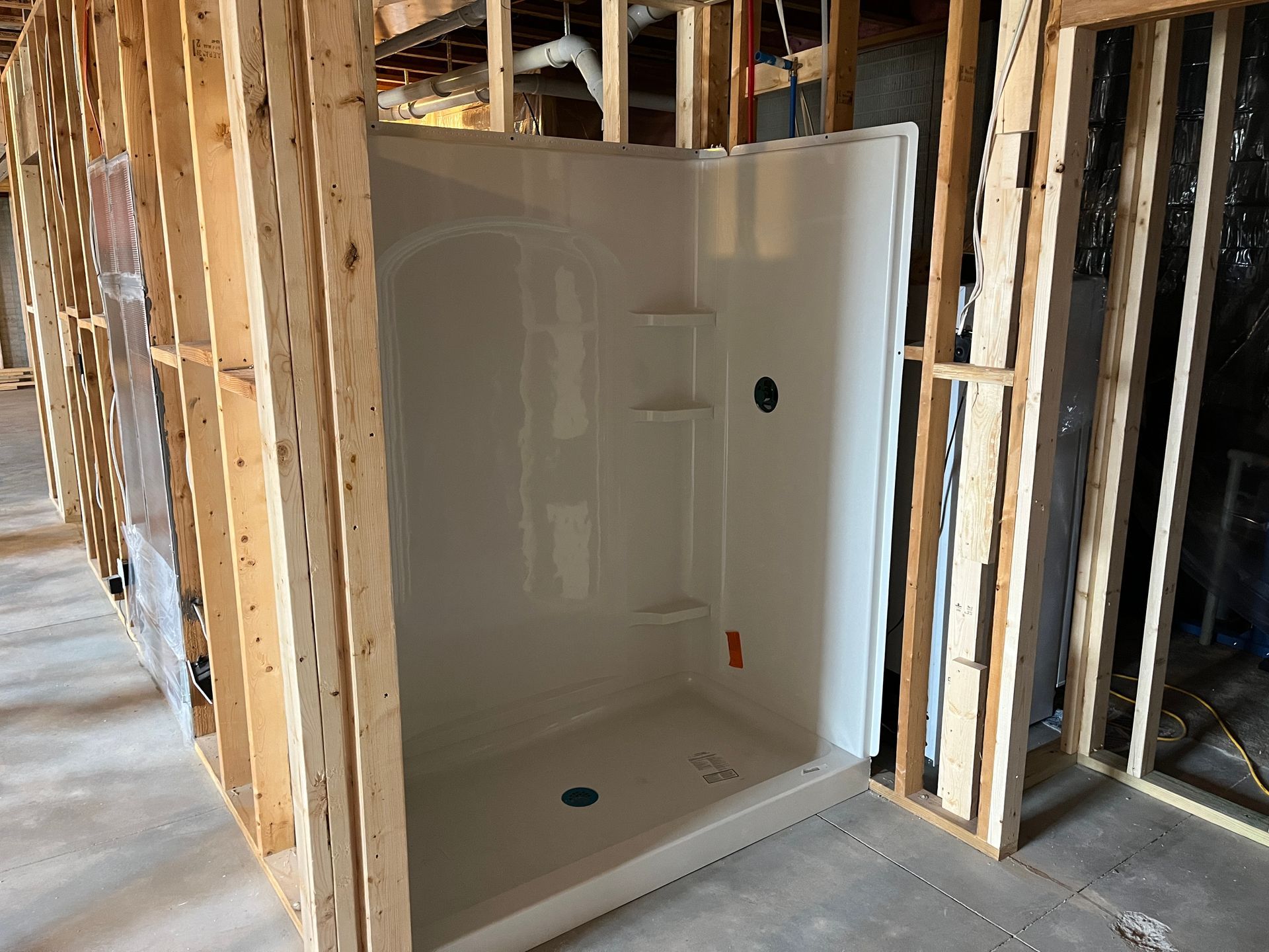 A shower stall in a building under construction.