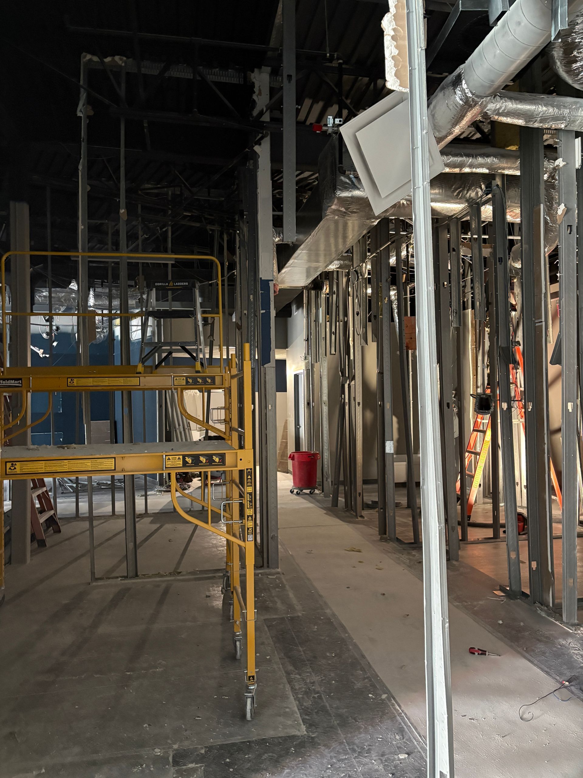 Construction site with scaffolding, support beams, and partially built walls.