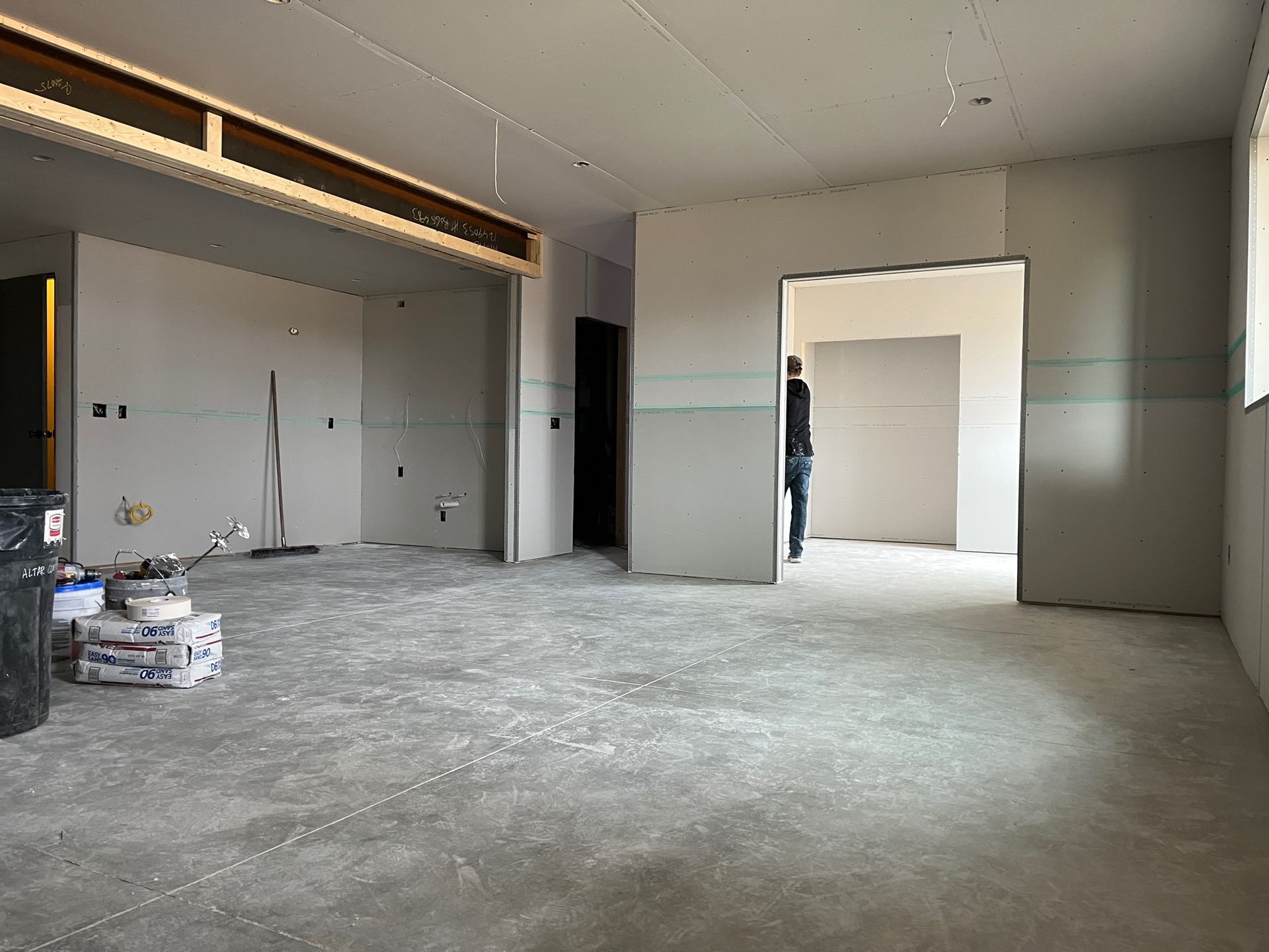 A man is standing in a room that is being remodeled