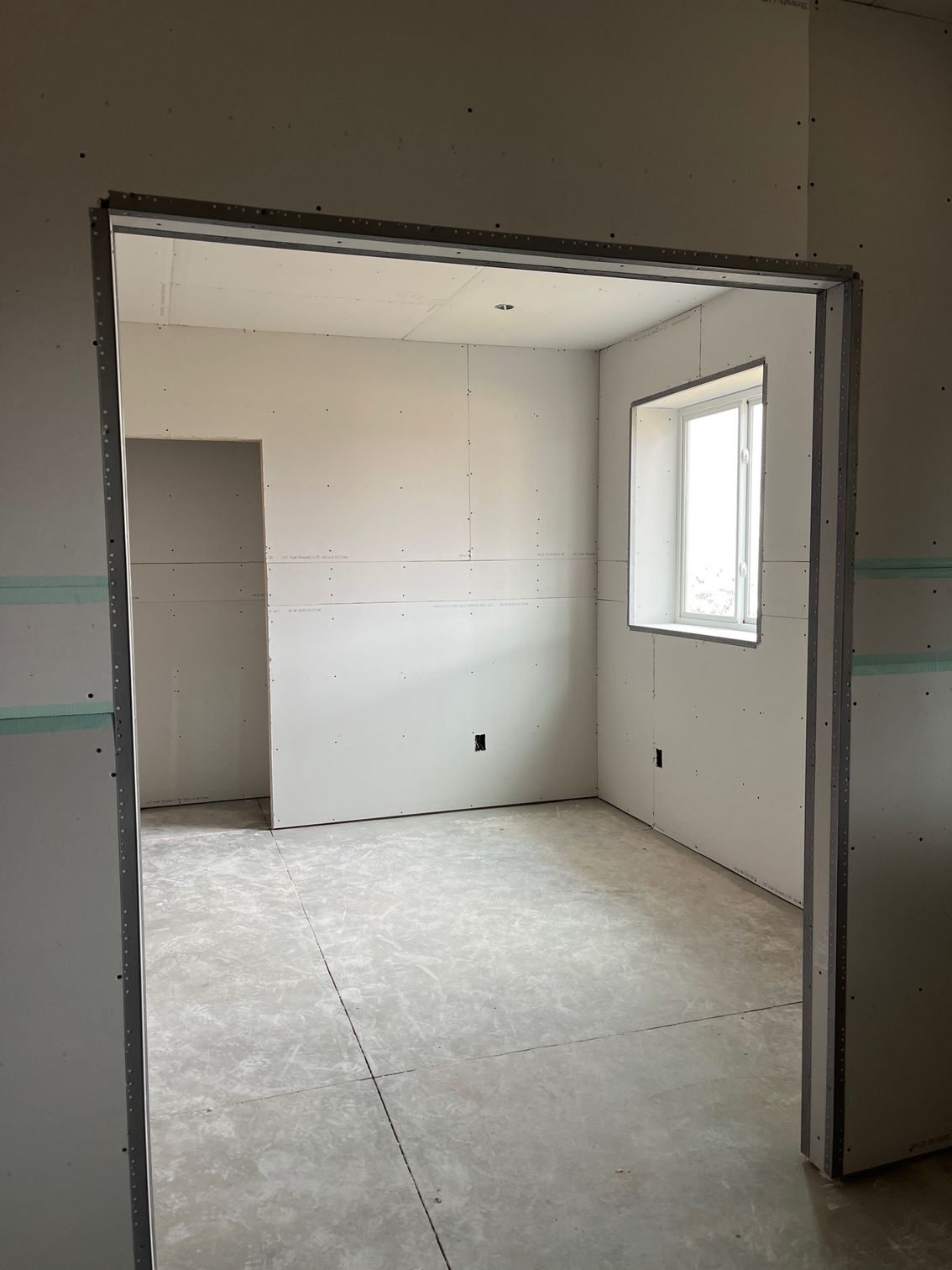 An empty room with a doorway and a window.