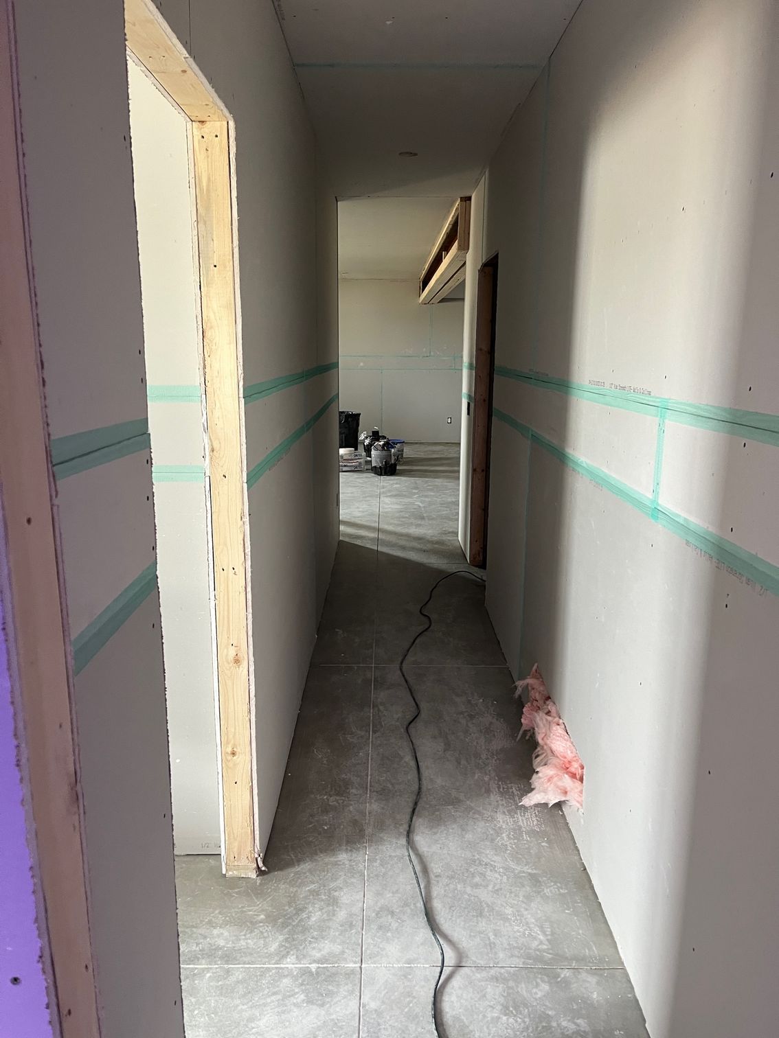 A long hallway with a vacuum cleaner in the middle of it.