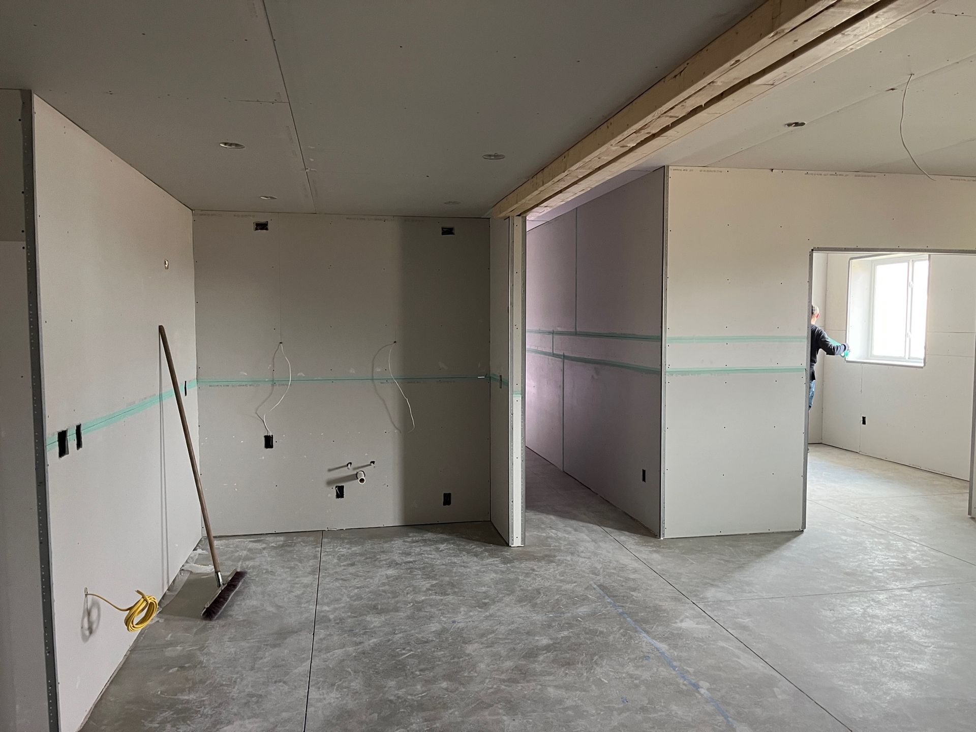 An empty room with a broom in the middle of it