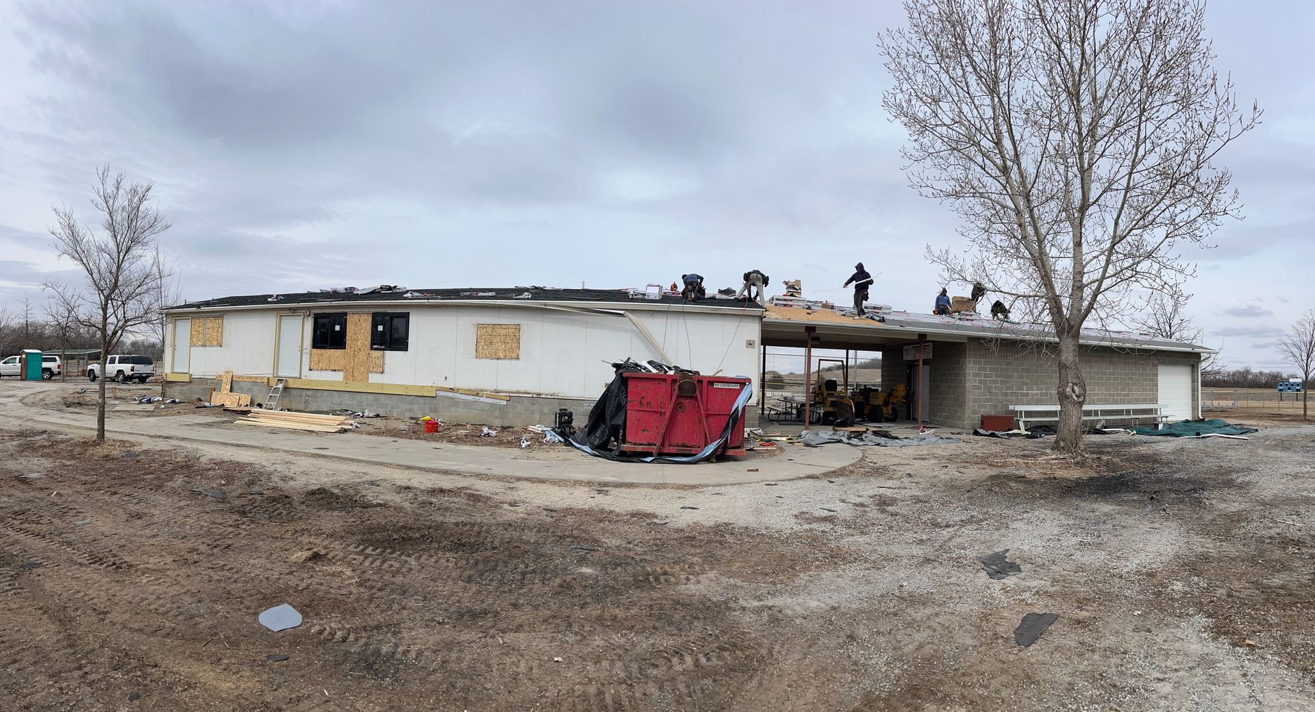 A group of people are working on the roof of a house.