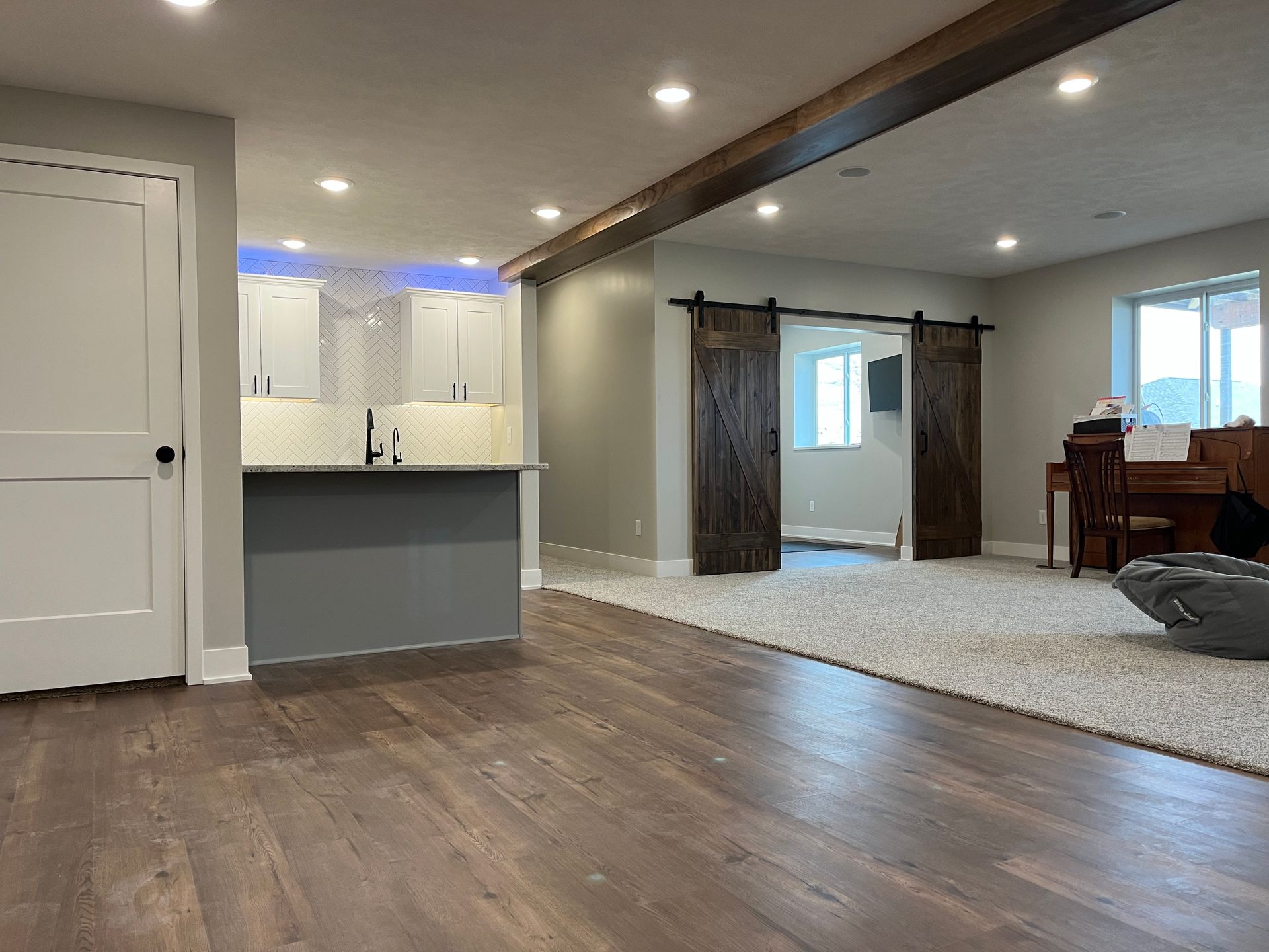 A living room with hardwood floors and a sliding barn door.