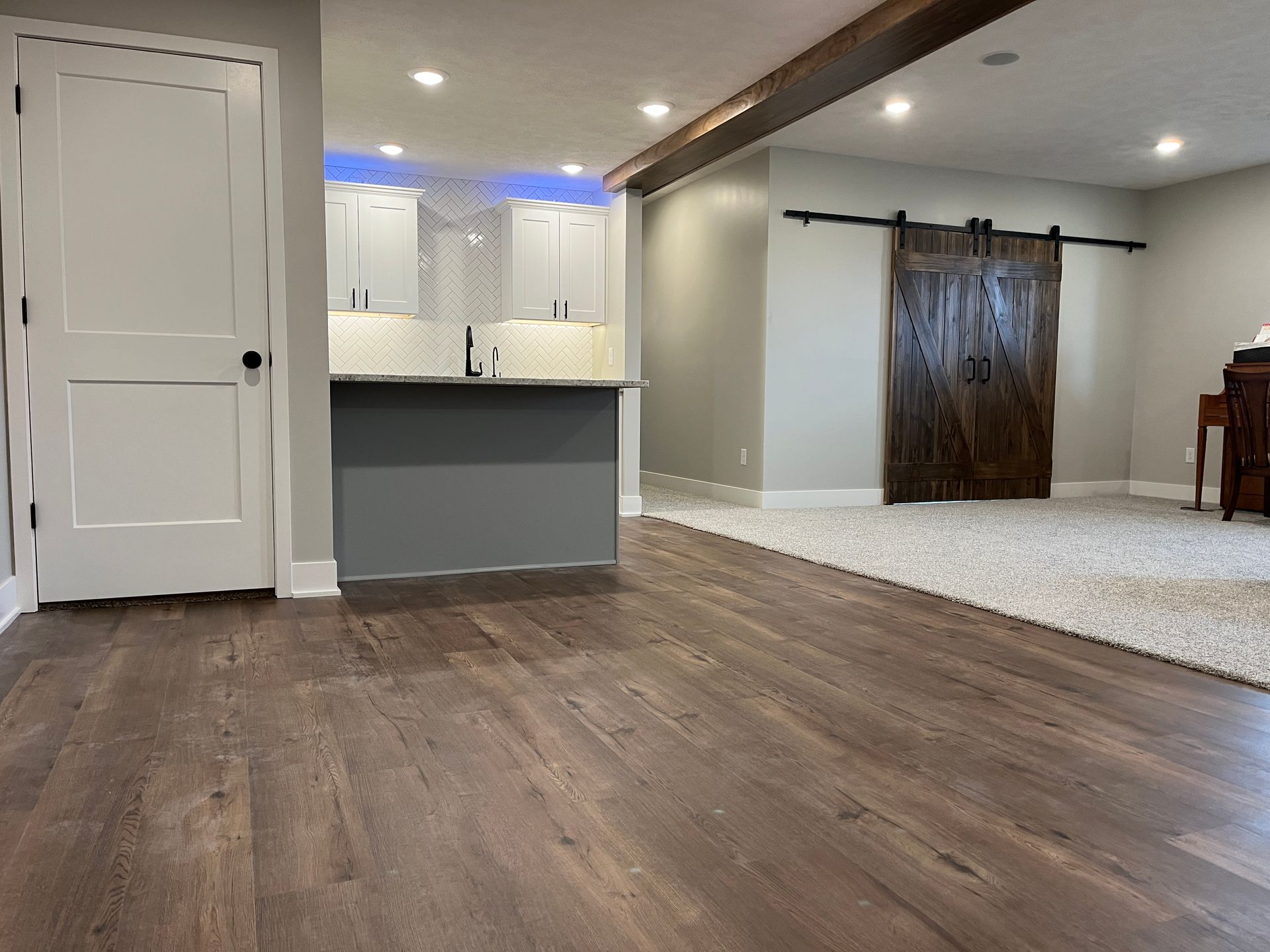 A living room with hardwood floors and a sliding barn door.