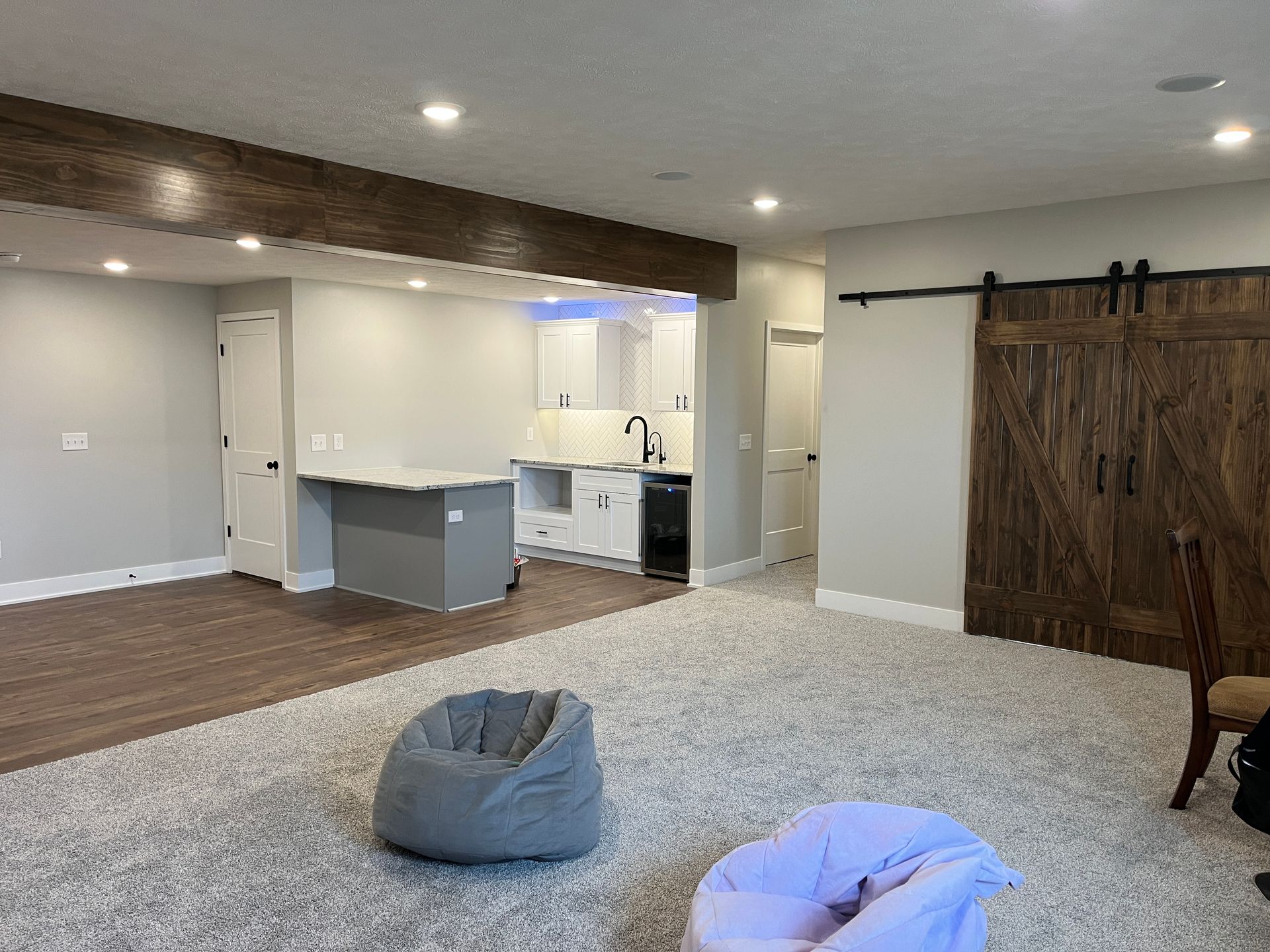 A living room with a sliding barn door and a bean bag chair.
