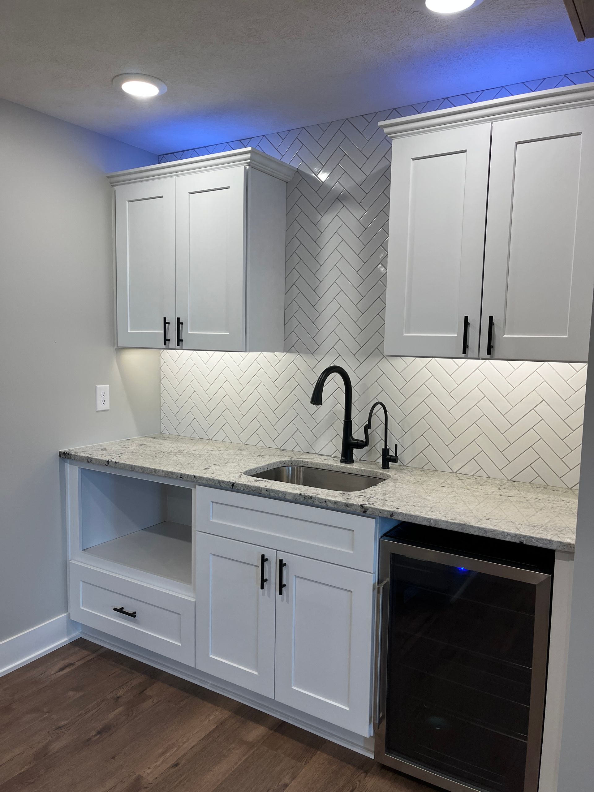 A kitchen with white cabinets and granite counter tops