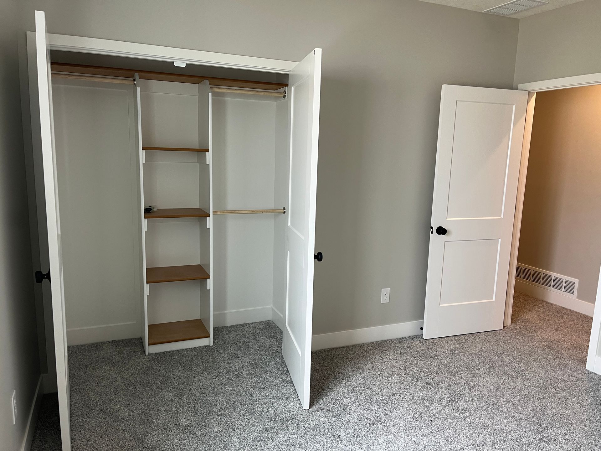 There is a closet in the middle of the room with the doors open.