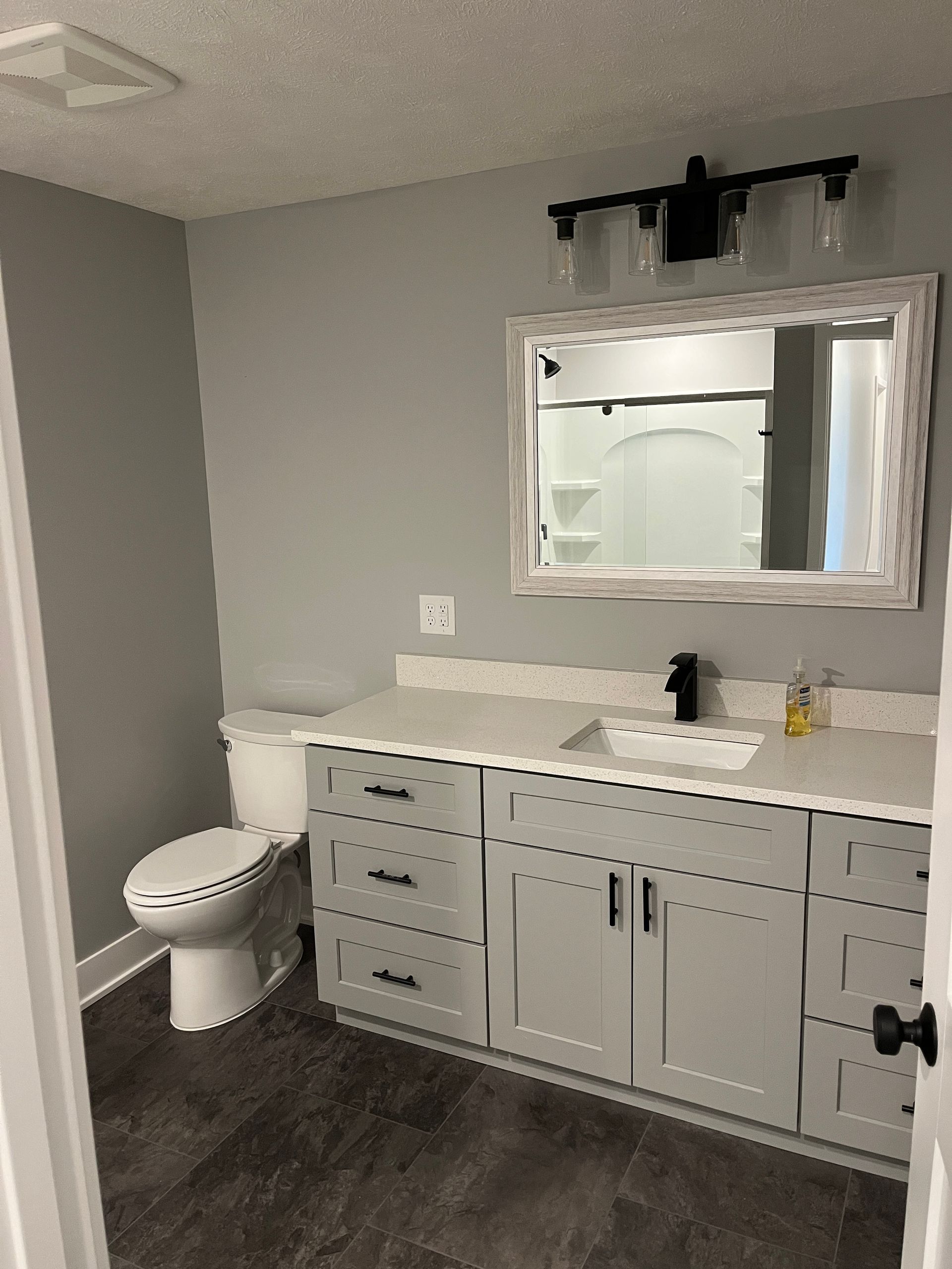 A bathroom with a toilet , sink and mirror