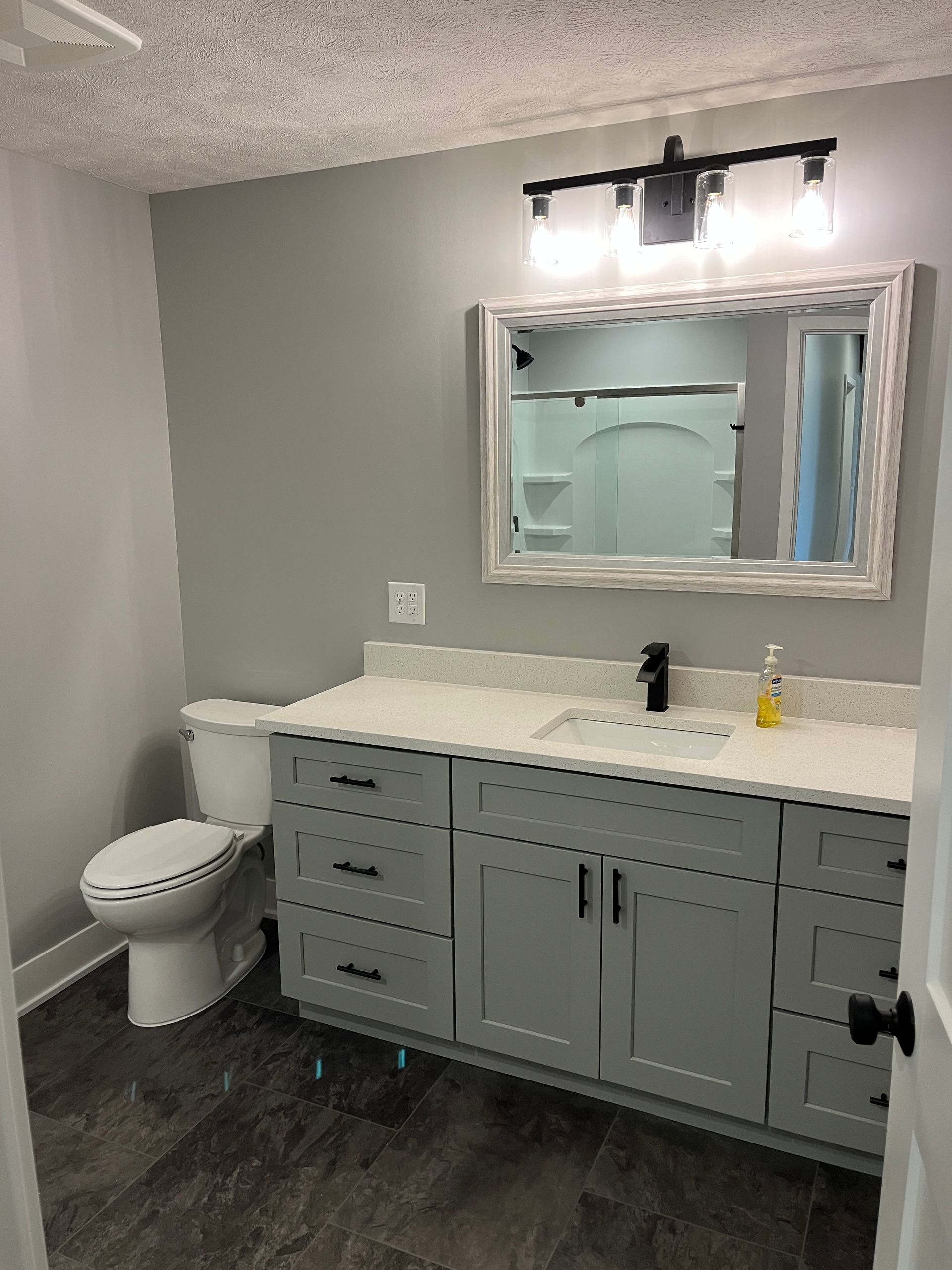 A bathroom with a toilet , sink , and mirror.