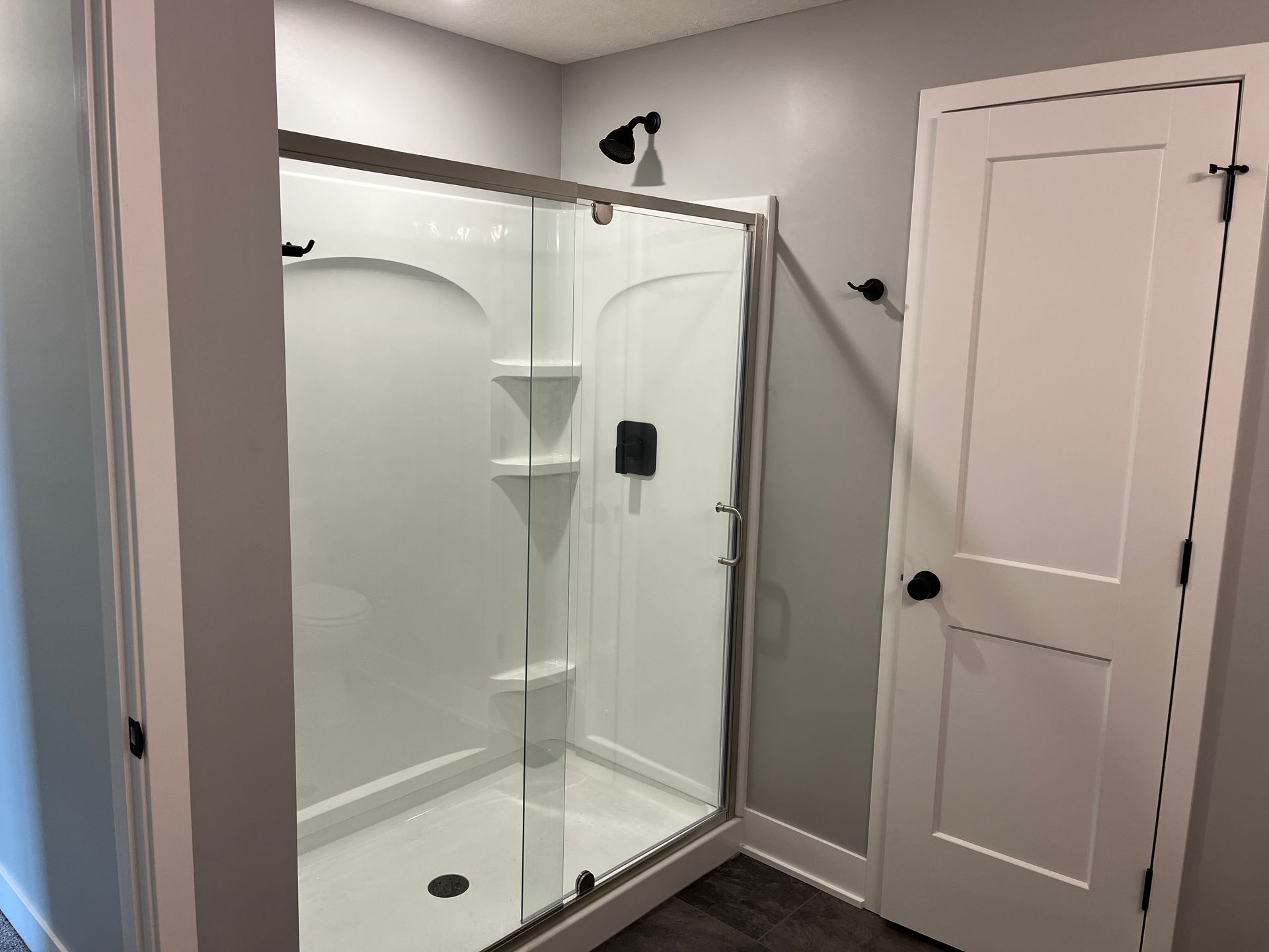 A bathroom with a walk in shower and a door.