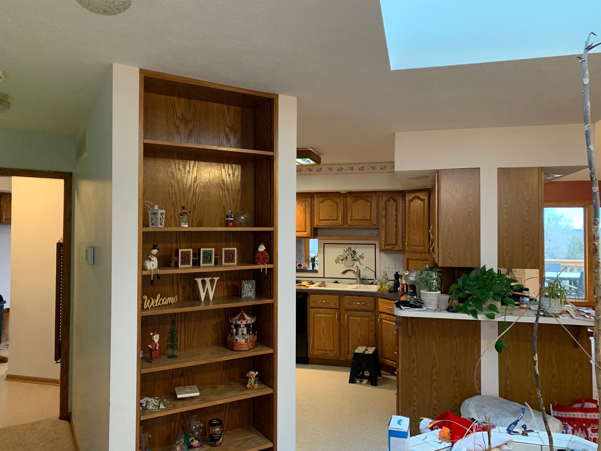 A kitchen with wooden cabinets and a shelf with the letter w on it.
