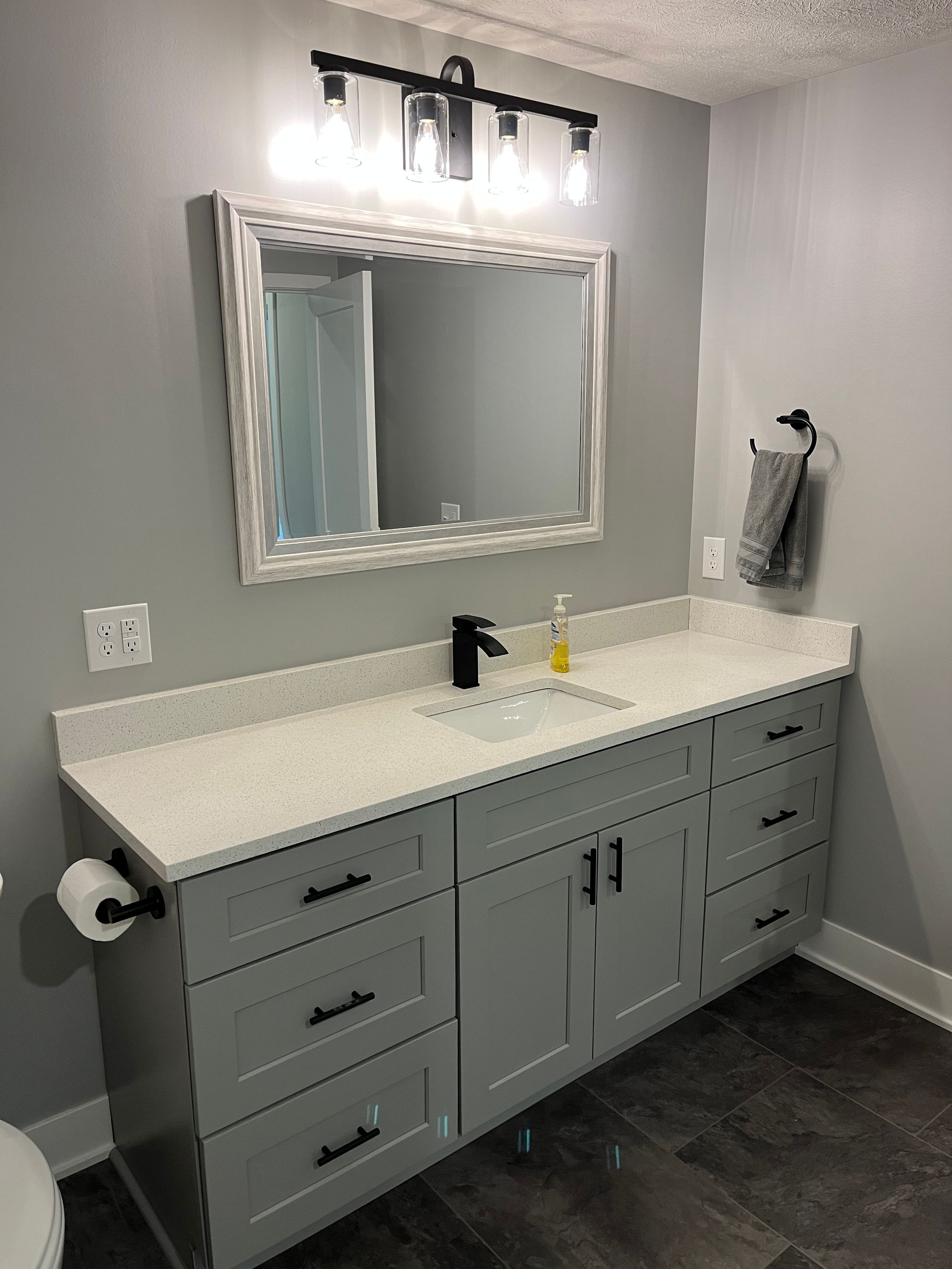 A bathroom with a sink , mirror and toilet.