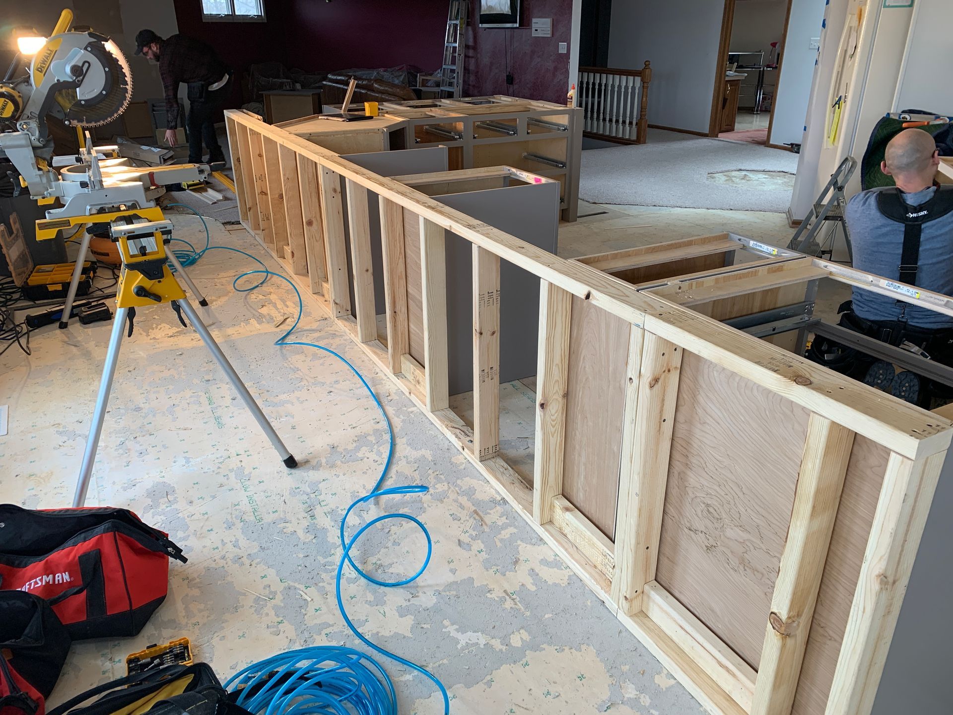 A man is working on a wooden wall in a room.