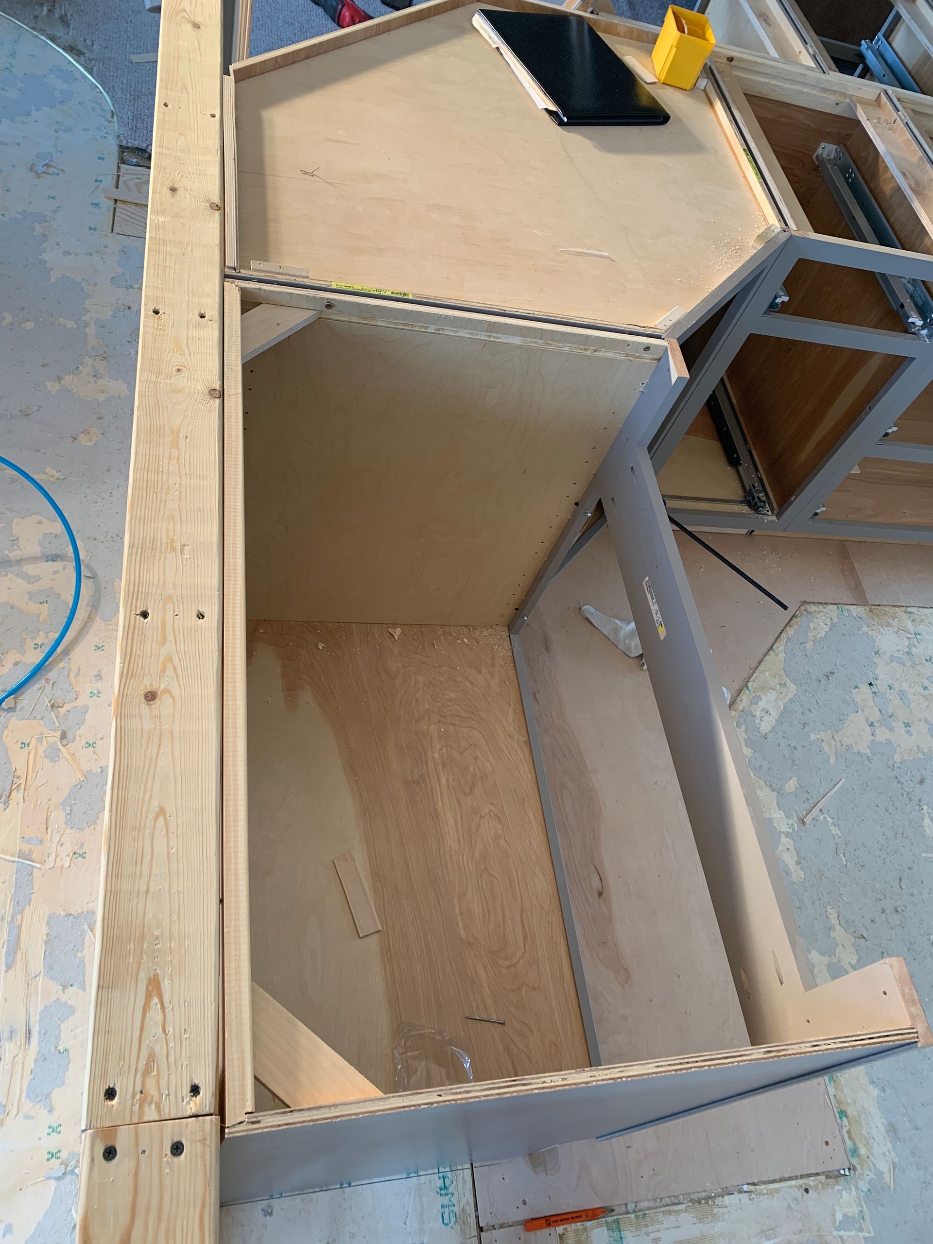 A wooden cabinet is being built in a room