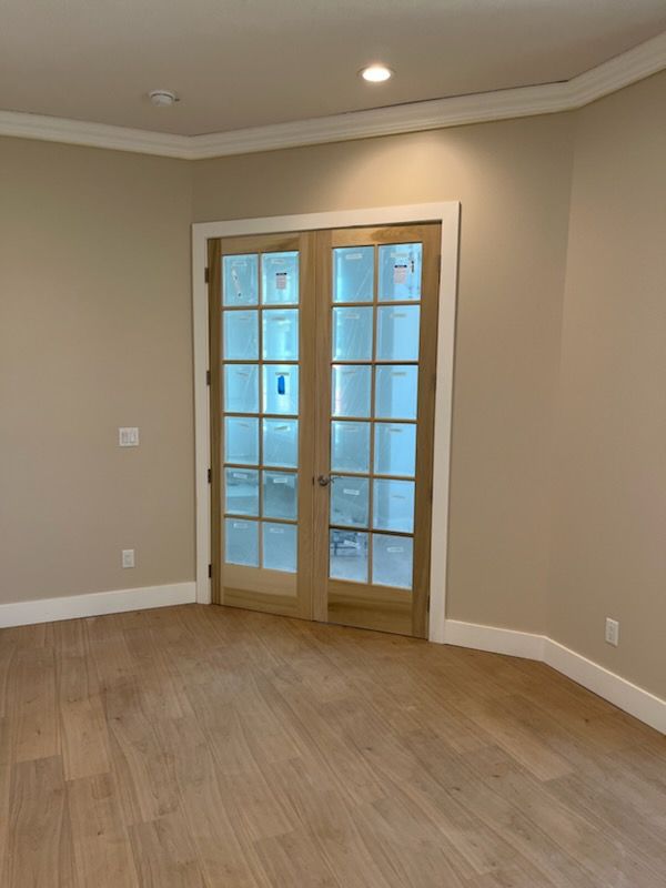 An empty room with hardwood floors and french doors