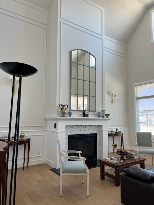 A living room with a fireplace and a mirror on the wall
