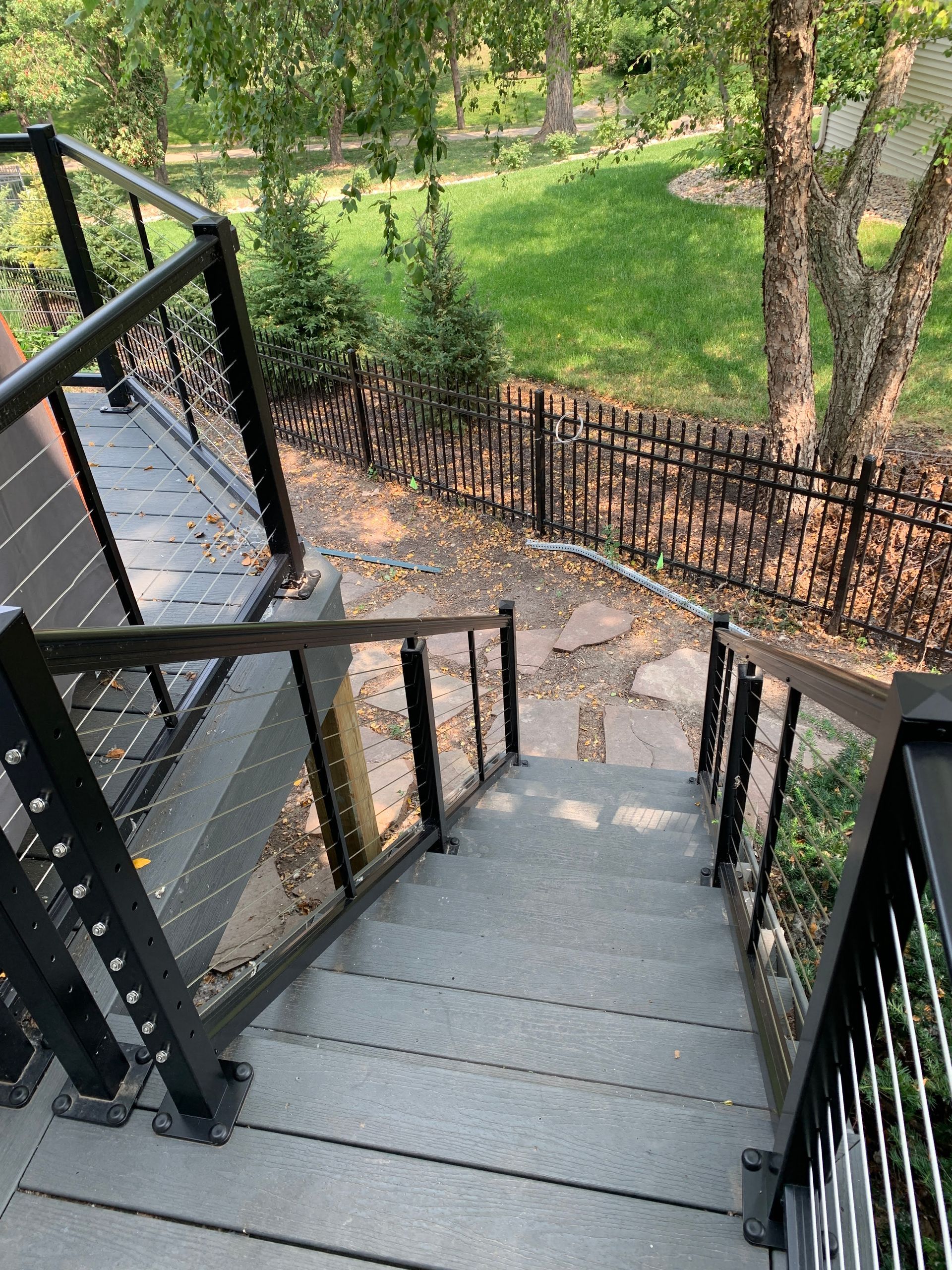 A set of stairs leading up to a deck with a fence in the background.