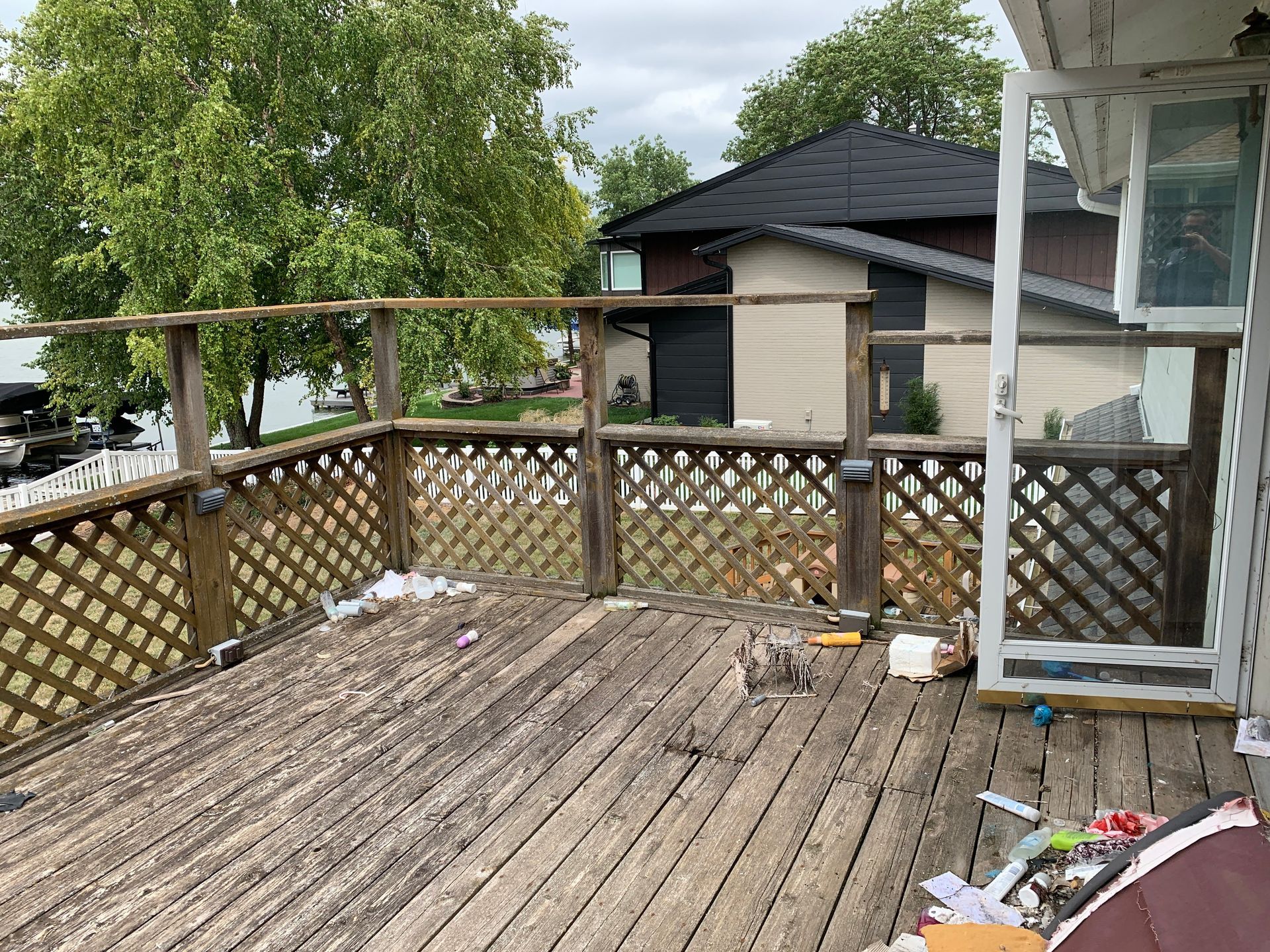 A wooden deck with a fence and a sliding glass door in front of a house.