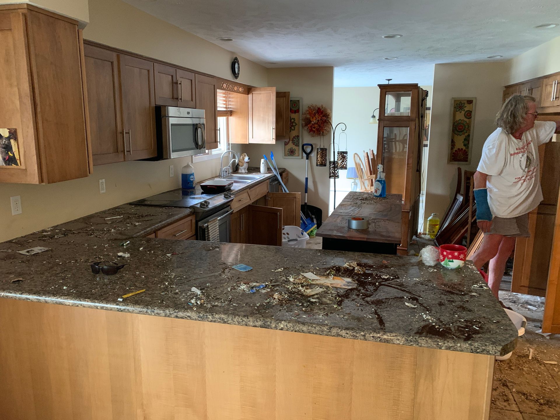 A woman is standing in a kitchen with a broken counter top.