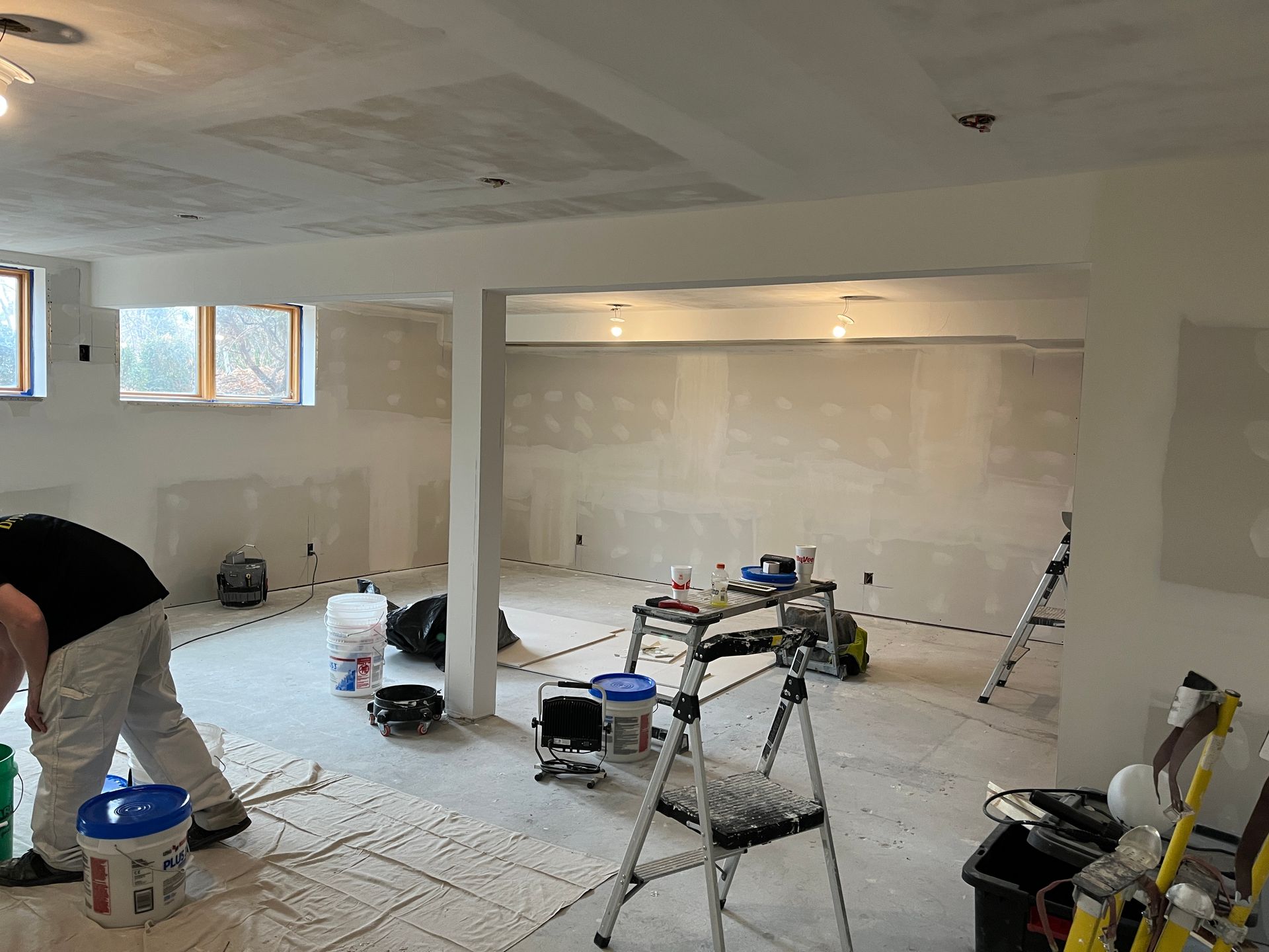 A man is painting a room in a basement.