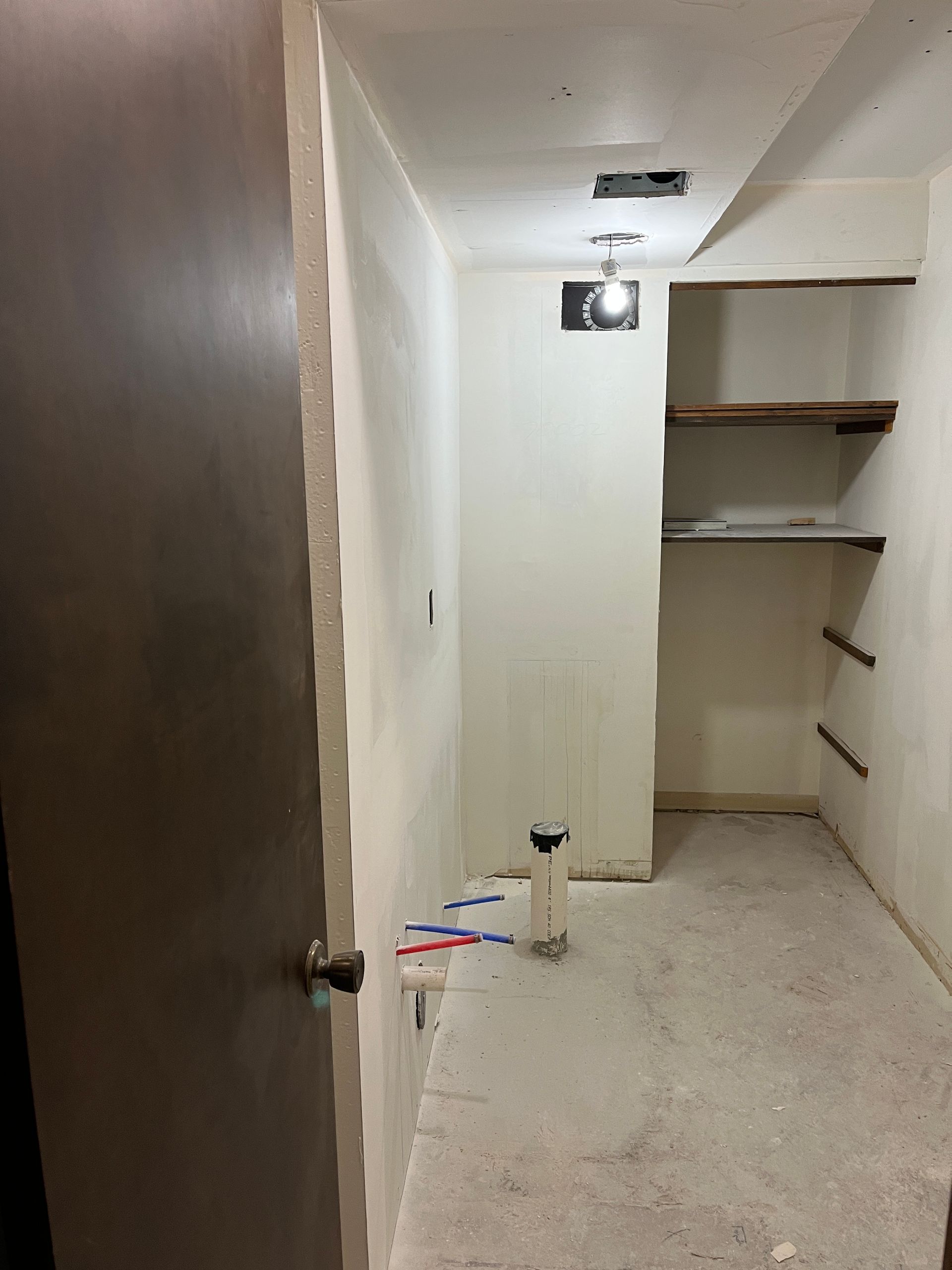 An empty room with a door and shelves in it