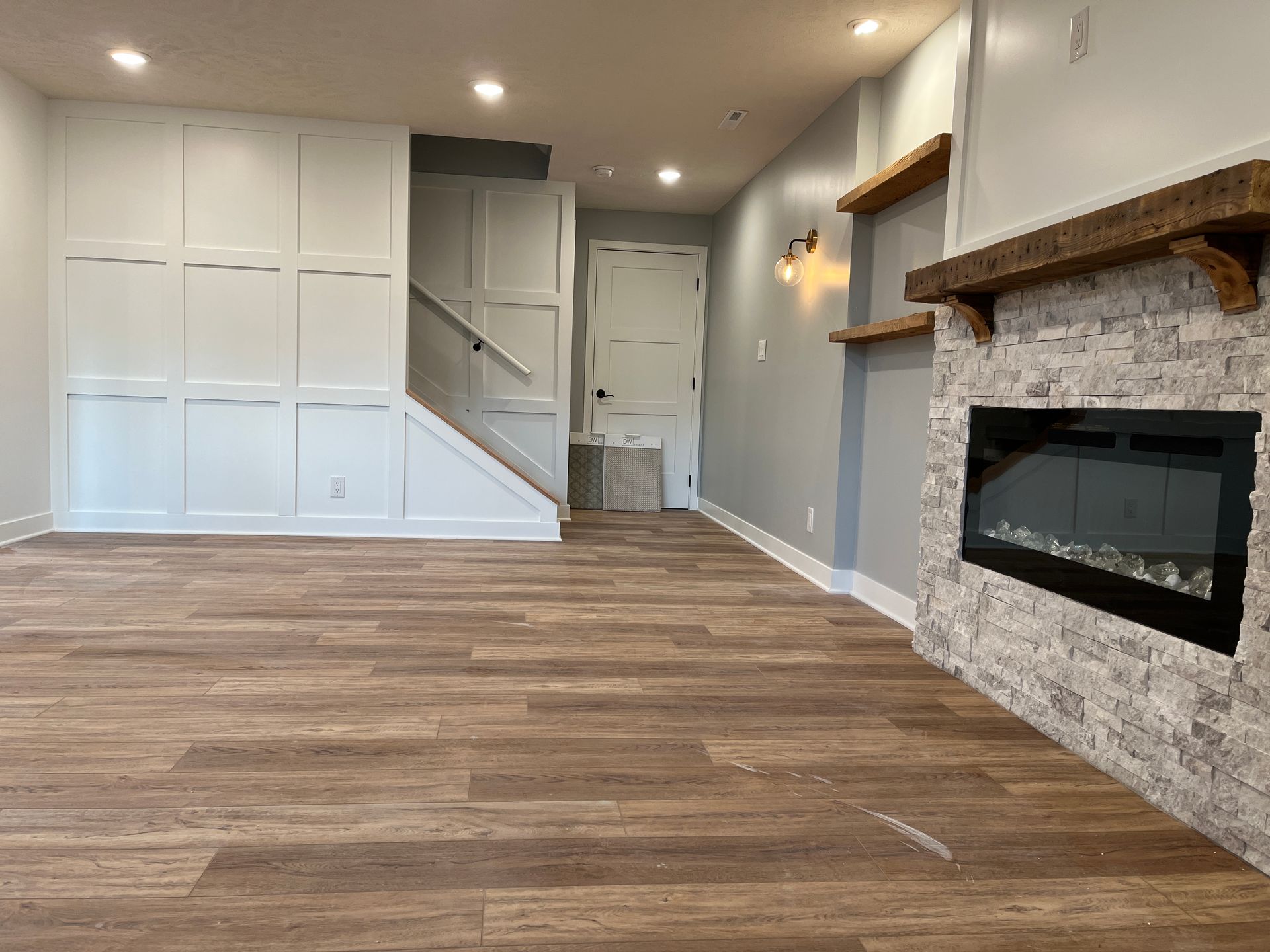 An empty living room with a fireplace and stairs.