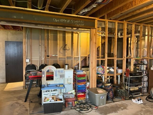 A room with a lot of wooden frames and a toy kitchen.