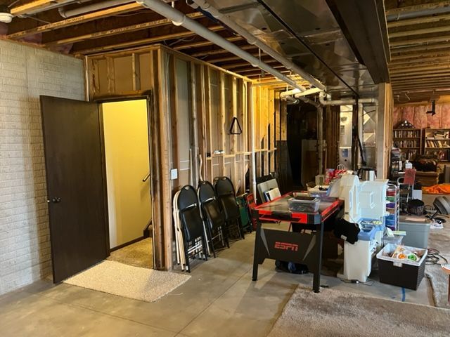 A basement with a table and chairs in it.