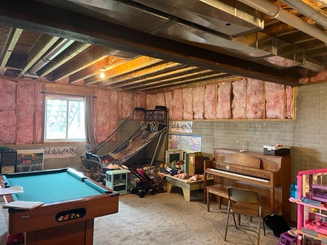 There is a pool table and a piano in the room.