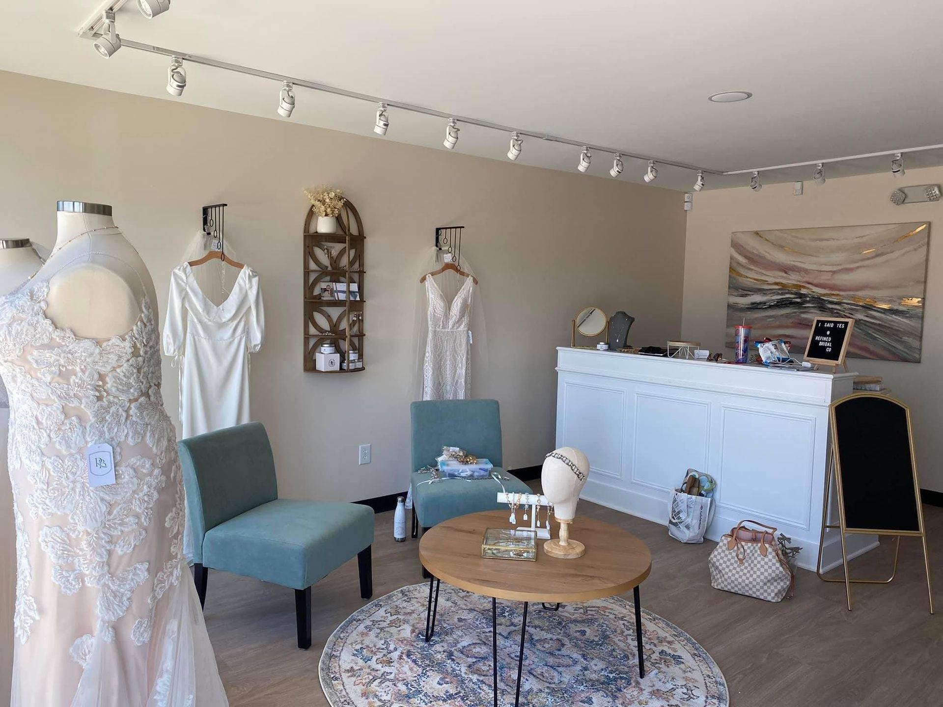 A room with a table , chairs , and mannequins.