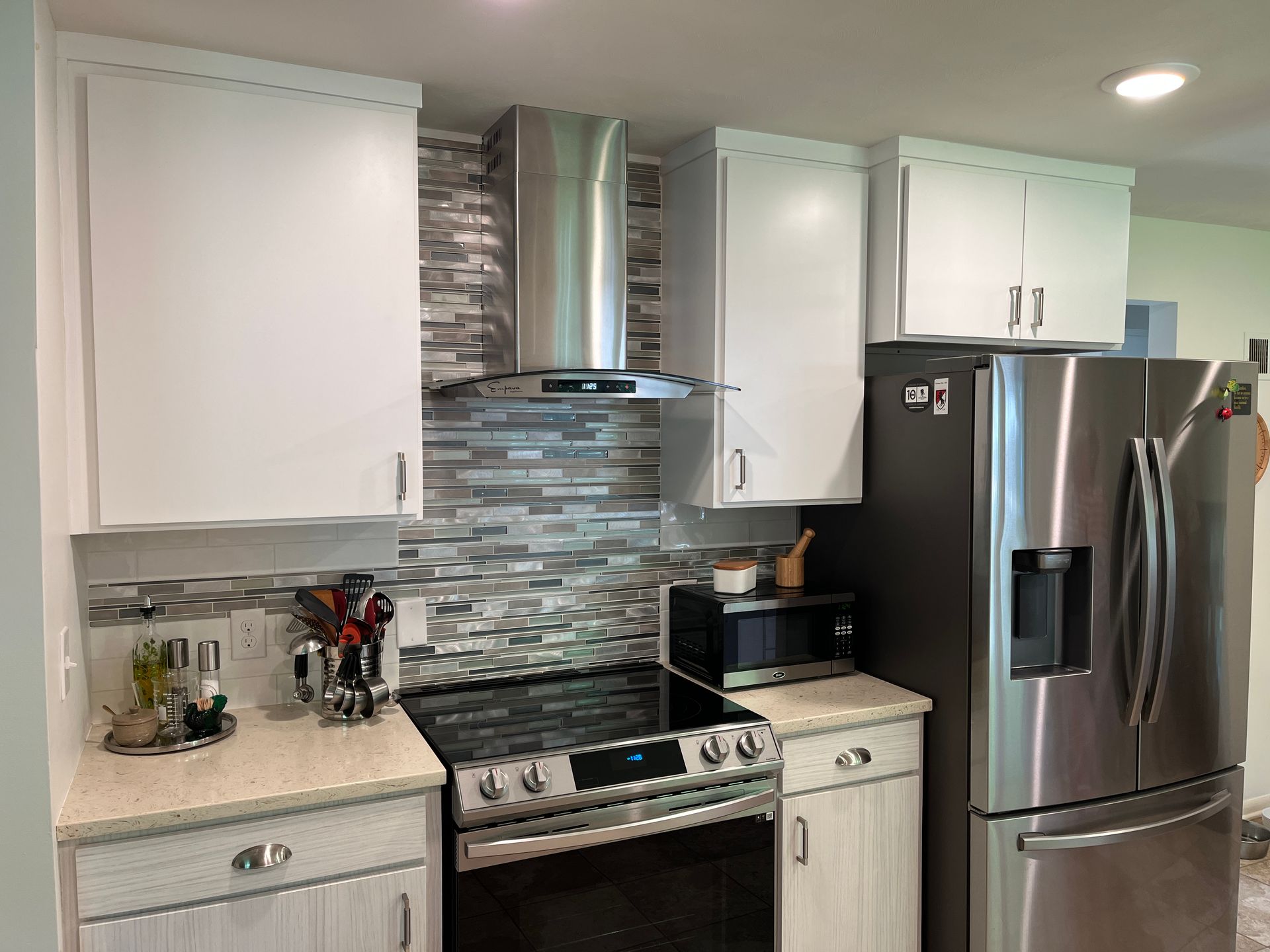 A kitchen with a stove , refrigerator , and microwave.